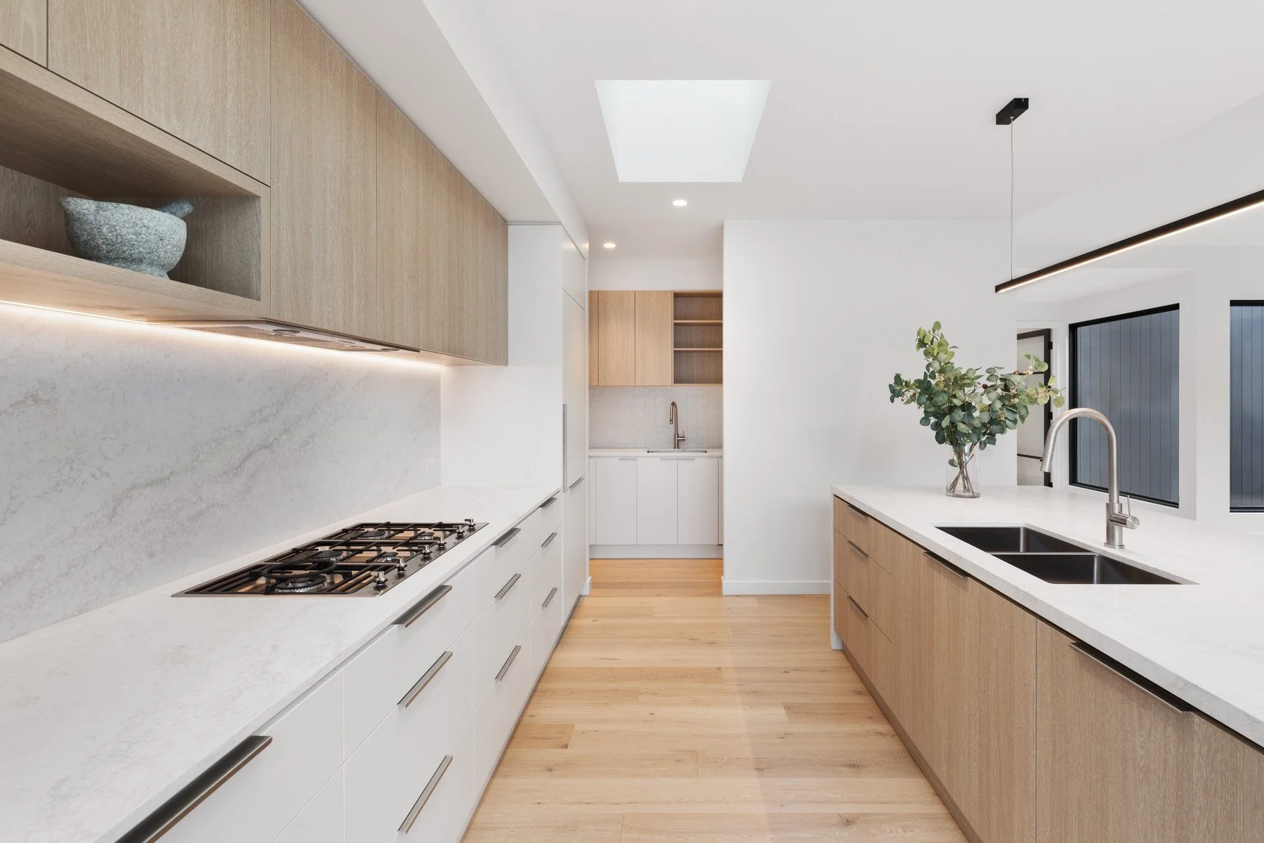 Entertainers kitchen with white benchtops and oak cabinetry