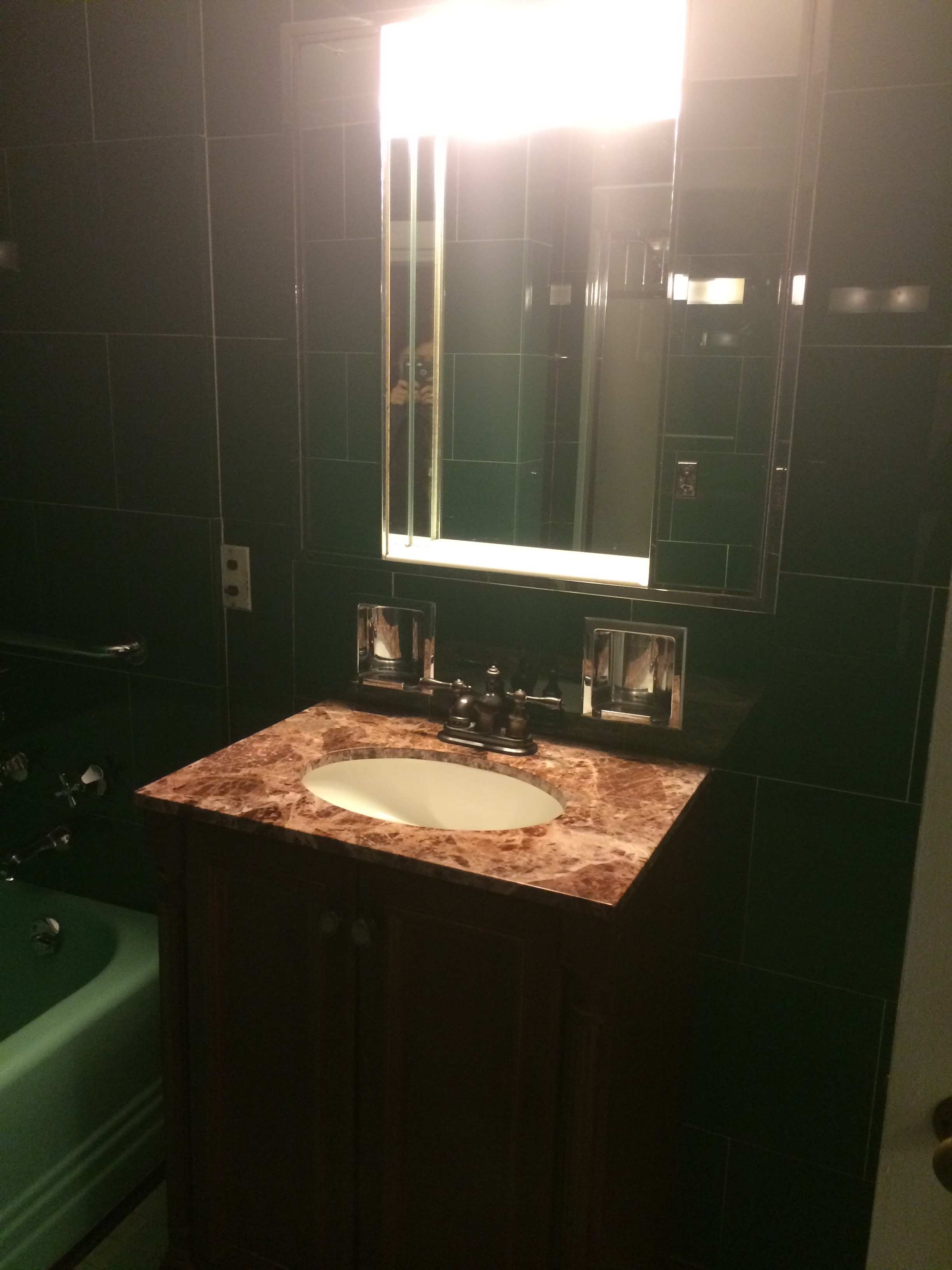 The single bowl vanity and klieg lights over the medicine cabinet. We suspect the green vanity top is somewhere in the attic.