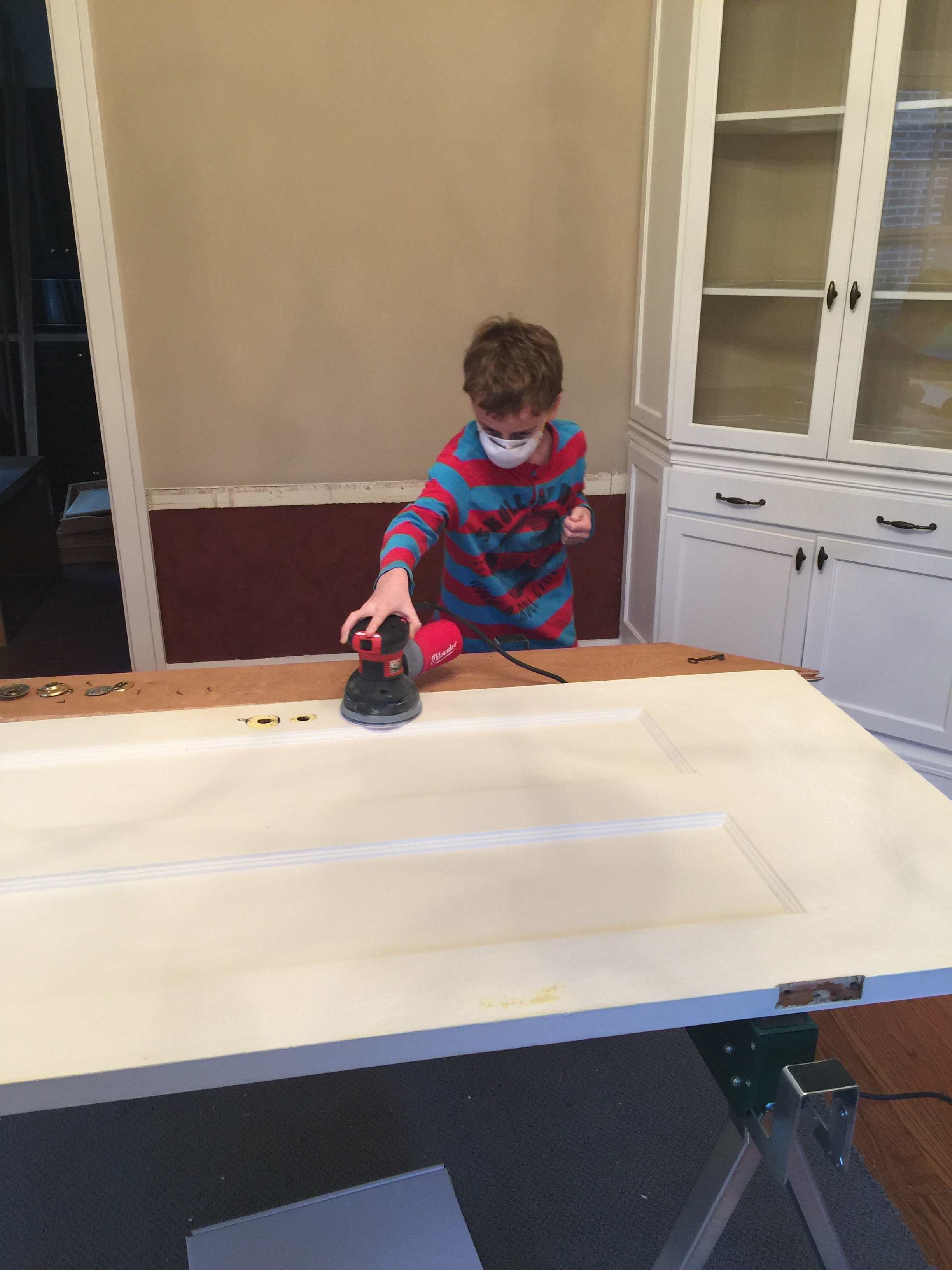 Not sure if he is walking the dog or the dog is walking him, but prepping an old door is a good rainy-day activity.
