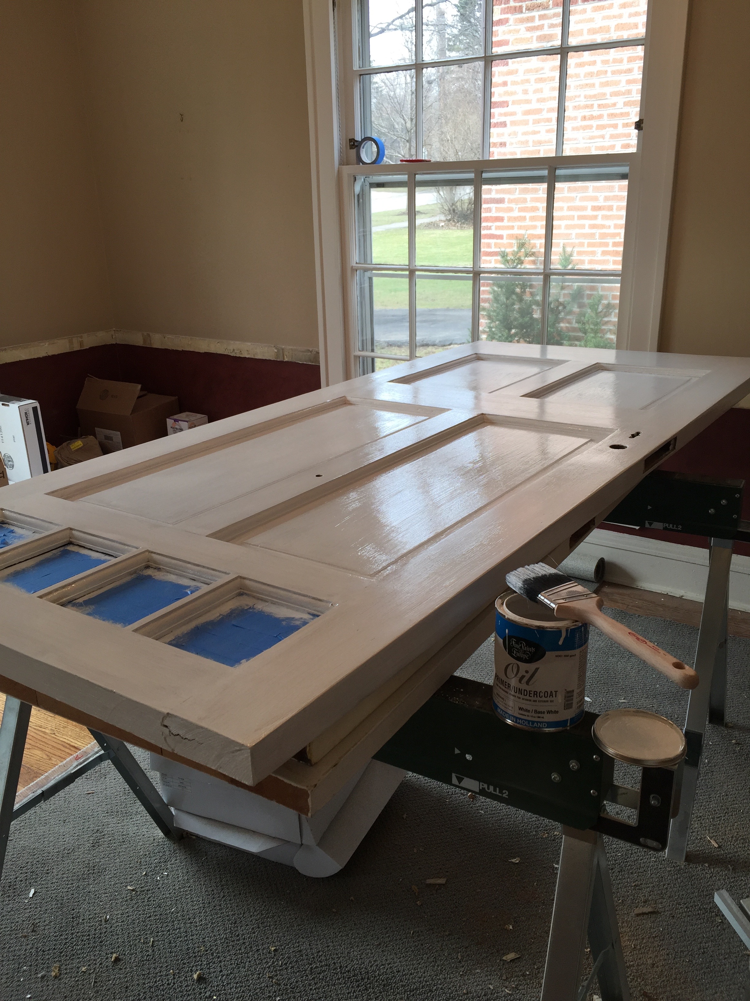 We saved the front door of the house from the landfill. After sanding it down to bare wood and repairing some minor damage, it received a coat of Hollandlac oil-based primer. 