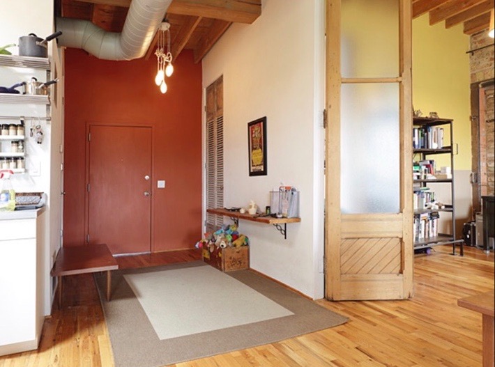 The original entry to the unit. Original wood floors, tall ceilings and passageways, and exposed ductwork are typical of the old Chicago loft conversions. 