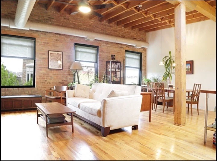 The combined family/dining room. Exposed brick with over-sized windows and large wood beams echo the industrial history of this building. The kitchen and family/dining room all bleed into each other in one large and undefined space during the pre-construction phase.