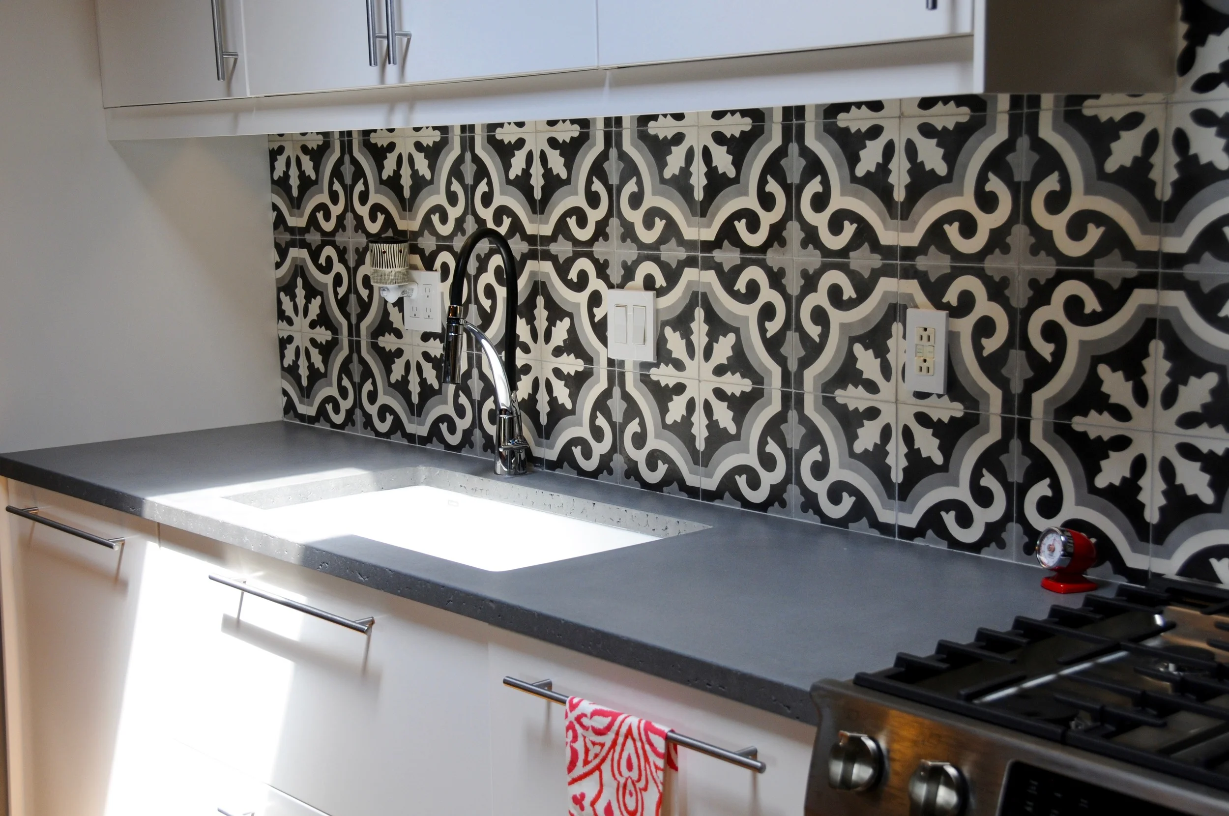 Countertops and backsplash are made from cement, a nod to the industrial history of the building. A skylight above the kitchen illuminates the workspace.