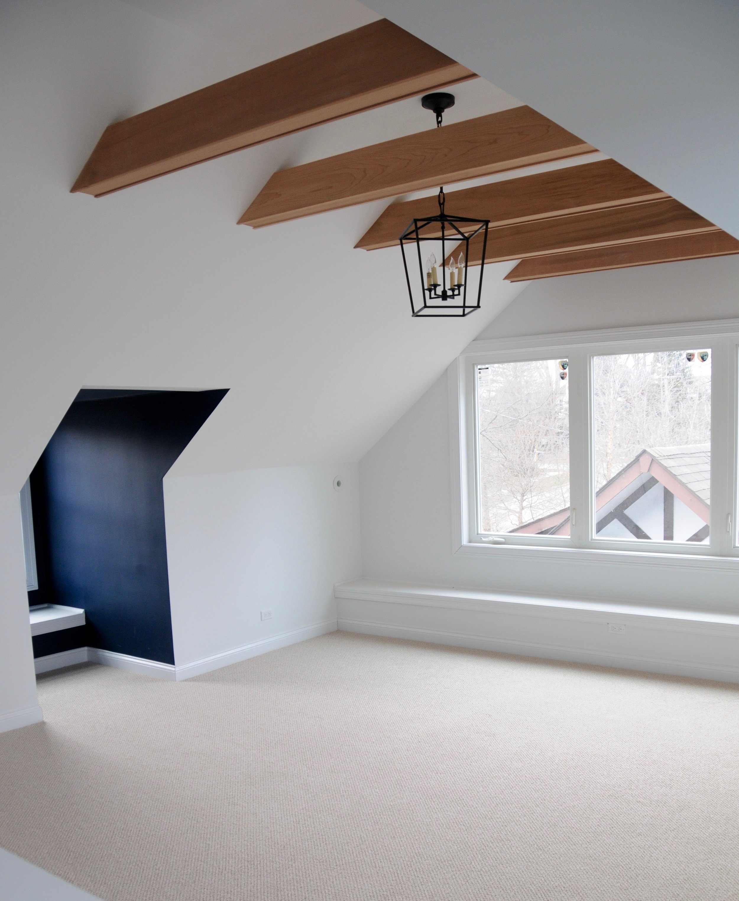 A view from the stairwell. Structural beams in the ceiling gave us the opportunity to dress them with clear cedar. New windows allow plenty of light into "the treehouse" and a long bench makes for a convenient perch. 