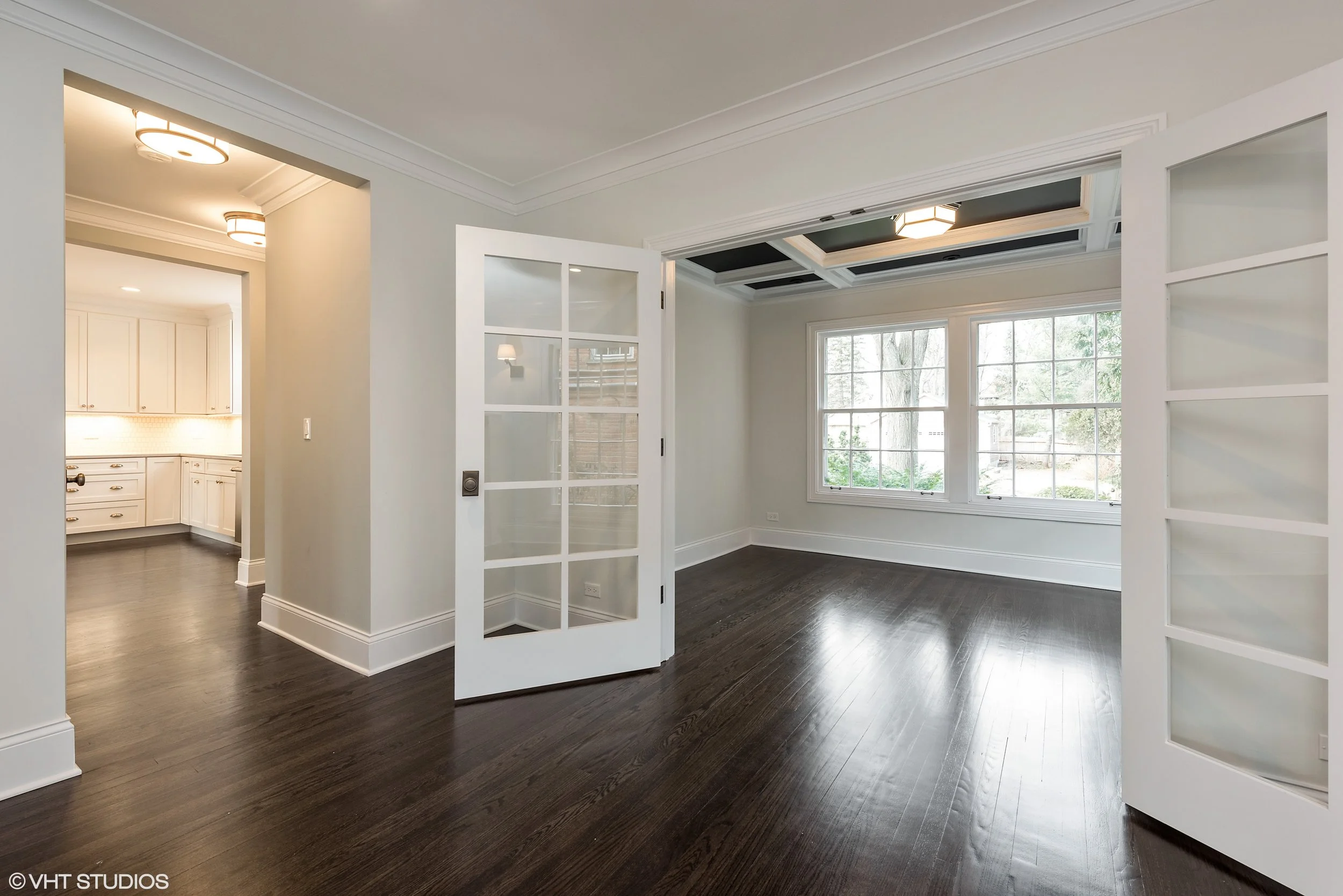 One way to reduce the "bowling alley" effect of the large colonial living room is to create some visual separation. In this example, we added french doors and a coffered ceiling to separate the study from the living room. We also added a passage to the kitchen to improve the flow of the house.