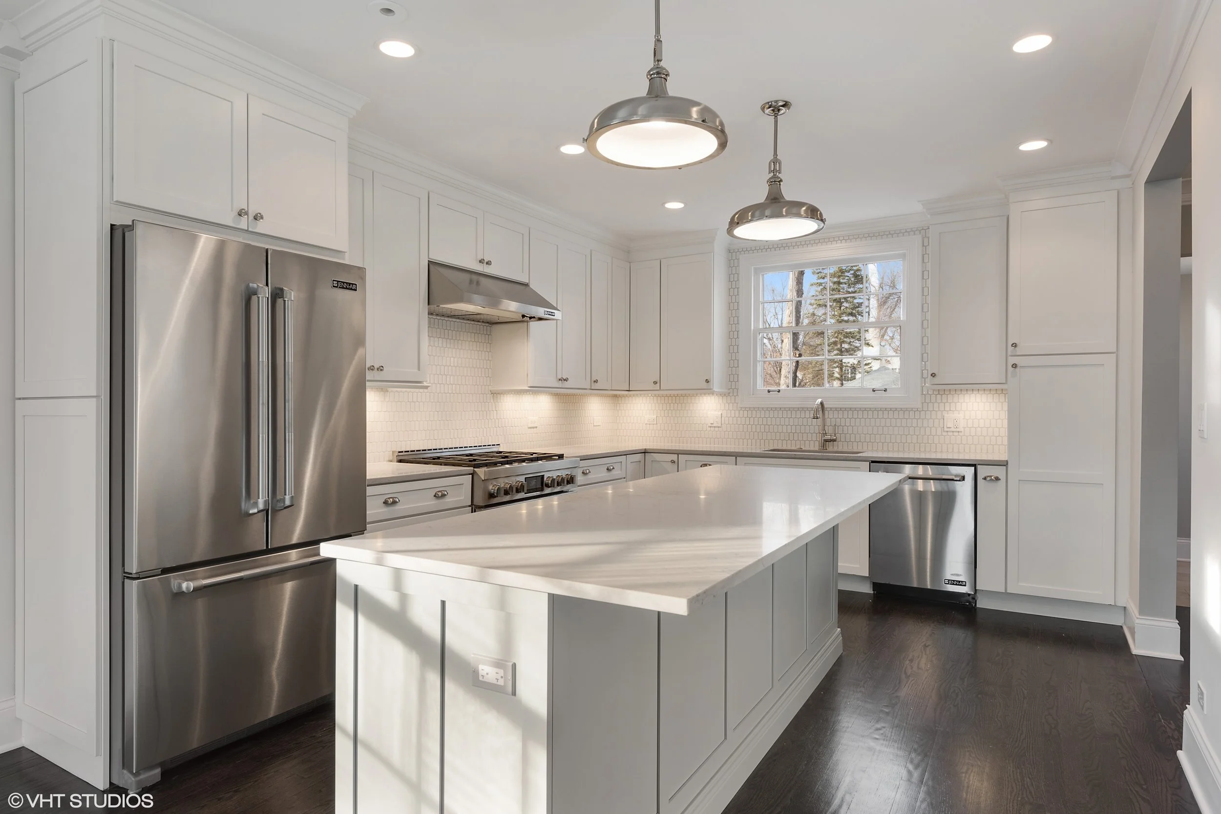 The kitchen was a prime example of adapting the layout to today's family: small, dark and closed off by a wall where the refrigerator is now, the new kitchen benefitted from a more spacious expansion, as well as new appliances, cabinetry, and lighting.
