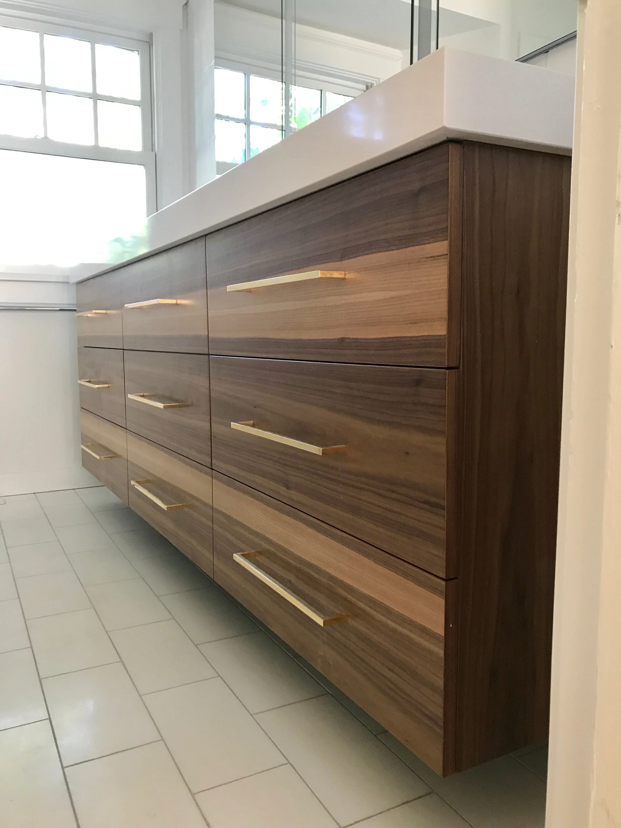 Outfitted with solid brass pulls and suspended over Thassos white marble, we used steel braces to keep it firmly mounted on the wall. It's mass appears to be levitating over the floor. 