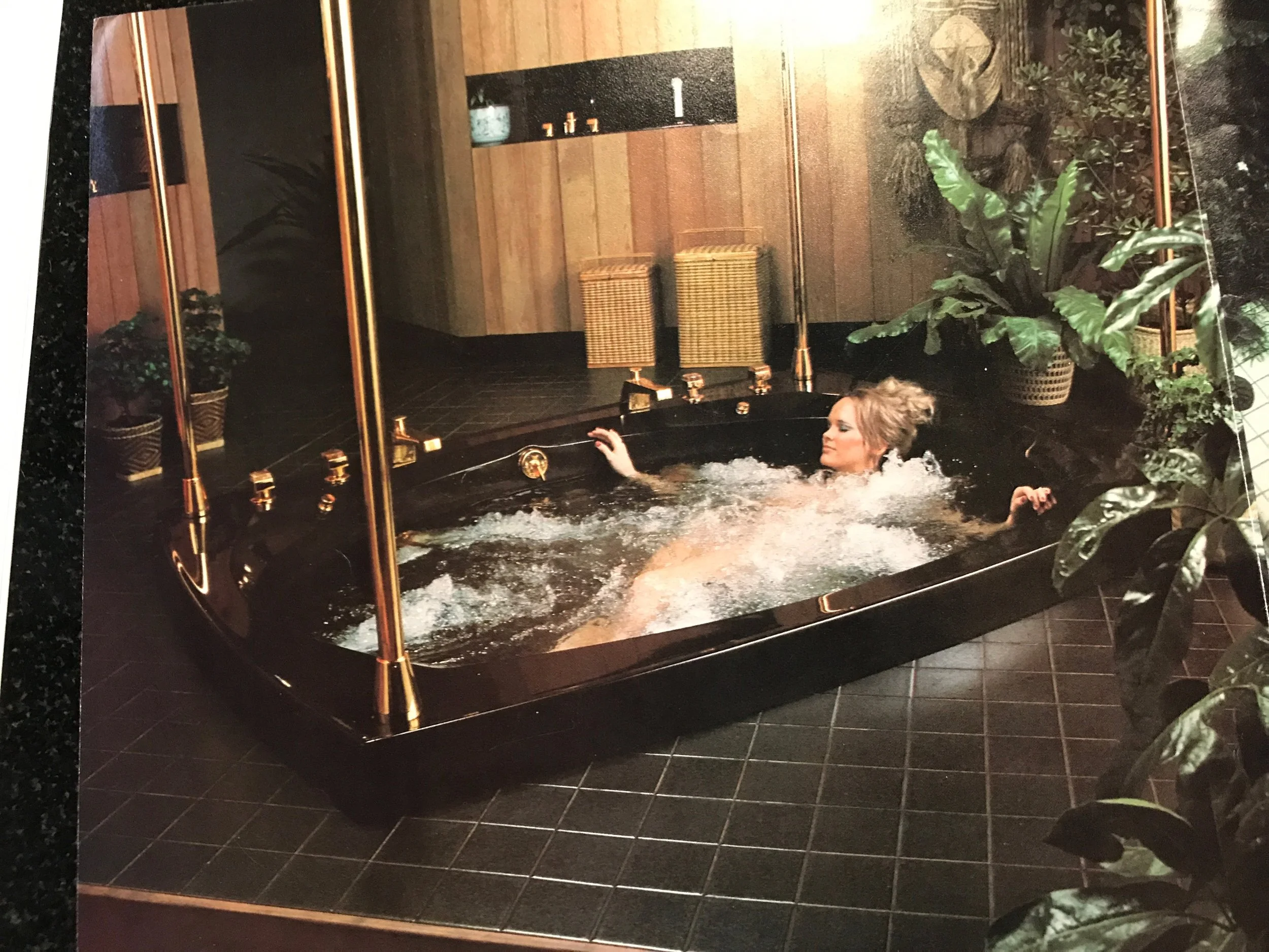 We can't get enough of the period-specific marketing materials. Brass poles for disco night. Or maybe those posts are holding up the ceiling. Does the model look relaxed or afraid for her life in this picture? Is this tub in a green house? We have so many questions. 