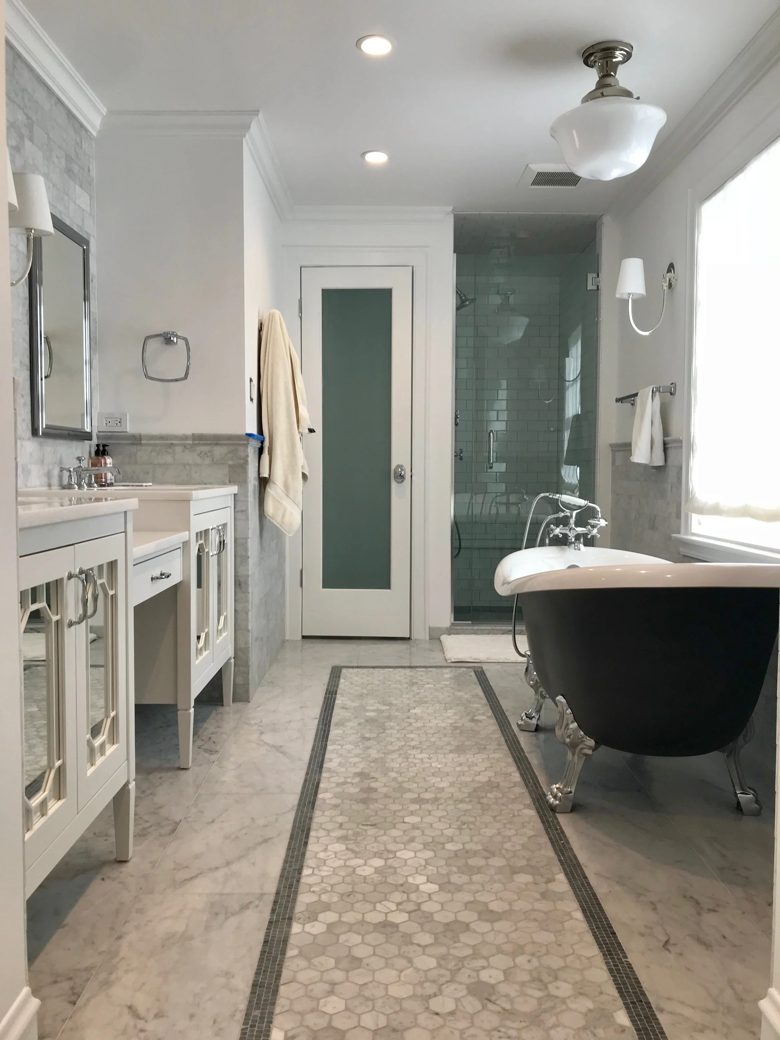 We recessed the 84" vanity into the wall to accommodate the free-standing tub. We used Walker Zanger's Grigio Scuro mosaic to create a border around the white carrara hex tile along the center line of the bathroom. 