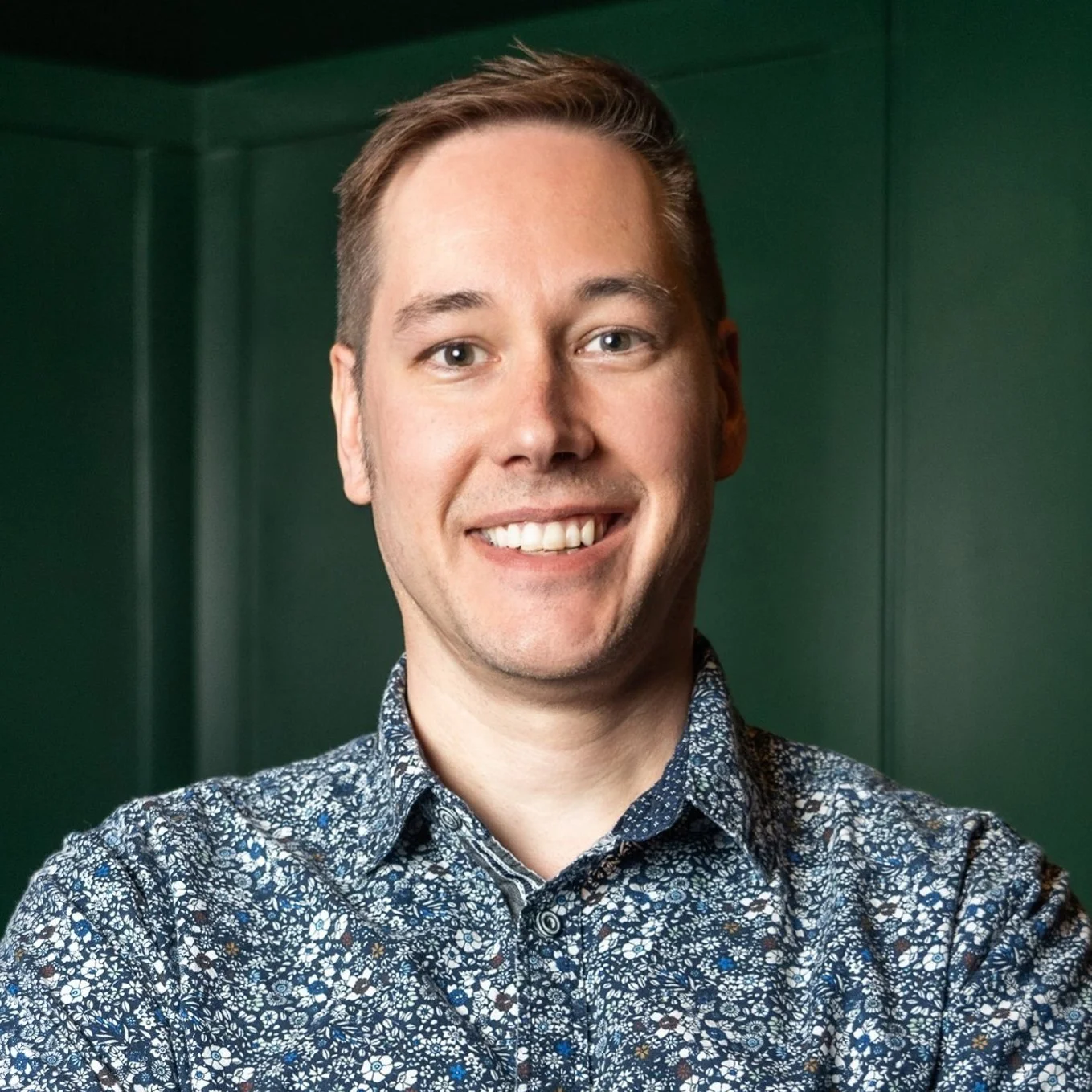 man short dark hair 50's blue and white small flowered shirt smiling into camera