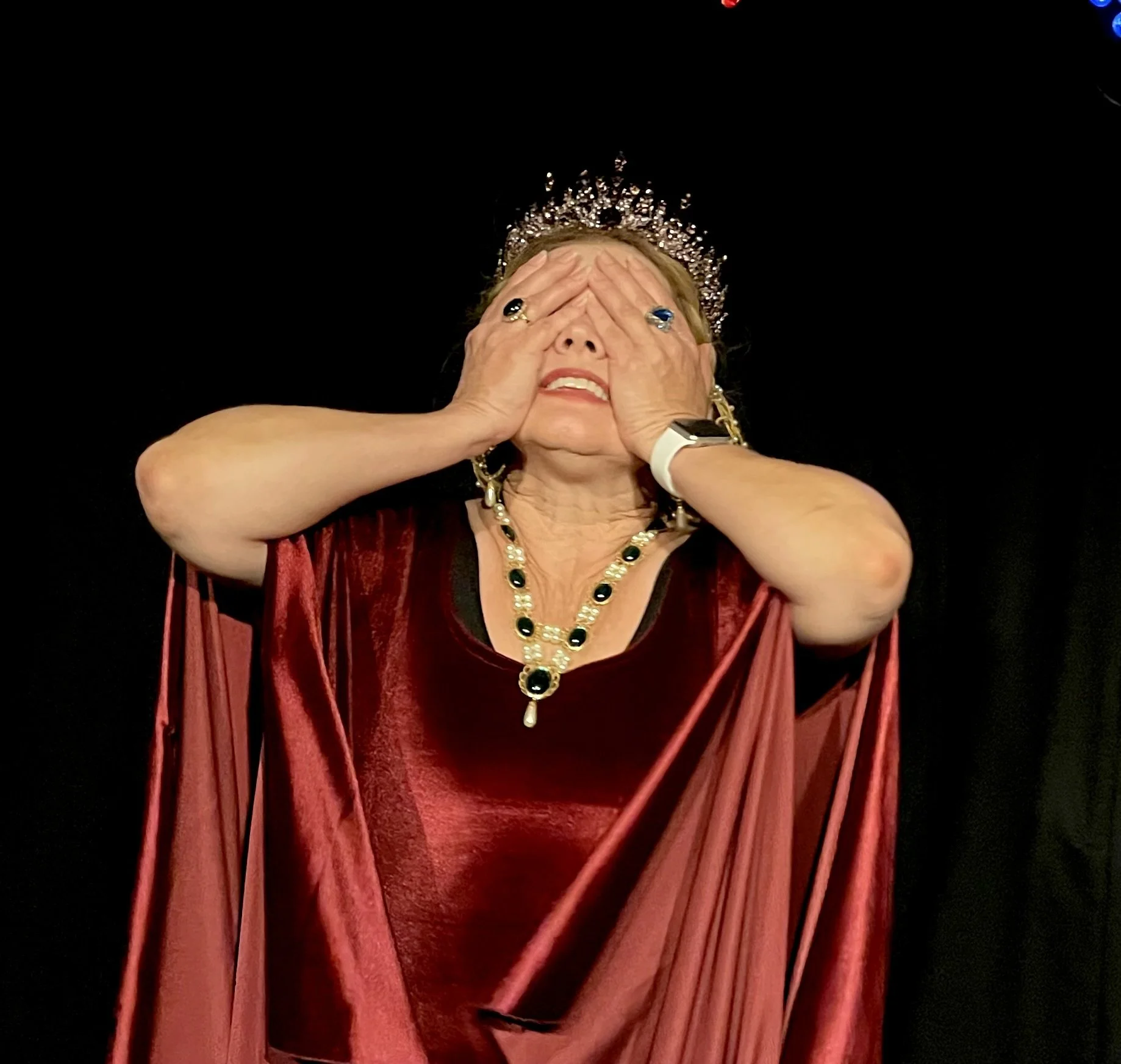 Woman in medieval dress and crown hands over eyes