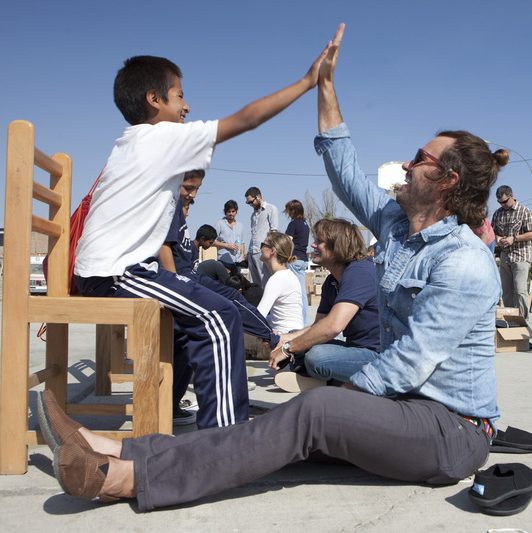 TOMS CEO Blake Mycoskie fits a Peruvian child with shoes. The company recently utilized virtual reality to help tell its story. 