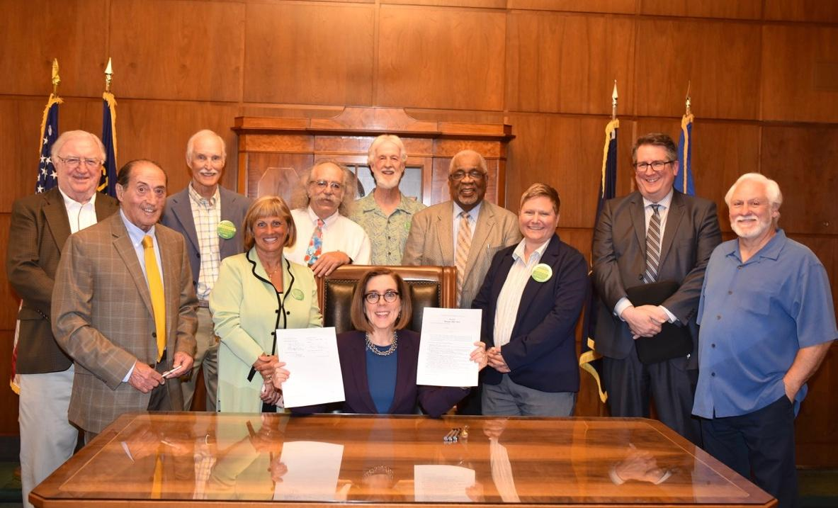 Governor Brown shows off a signed copy of Senate Bill 1013 that narrows what qualifies for capital prosecutions under Oregon’s death penalty law. Brown is surrounded by members of Oregonians for Alternatives to the Death Penalty, the leading advocacy group for SB 1013.