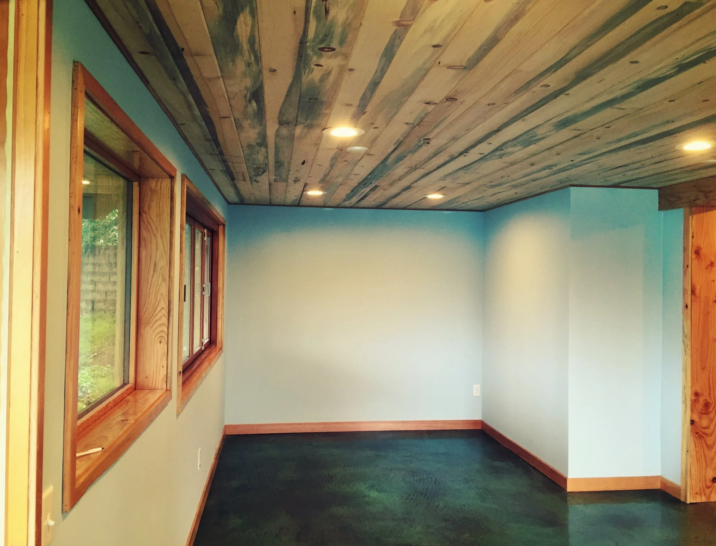 Sun Room Private Commission. Bellingham WA Built onto an existing house, the sun room was completed with an acid dyed & polished concrete floor, spalted wood ceiling with inset lighting, a south facing wall of sliding cedar windows, and exterior decking of Meranti wood. 