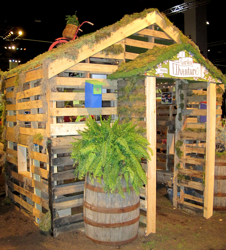 Wood palettes are put to use in a building and fencing for this educational children's garden.