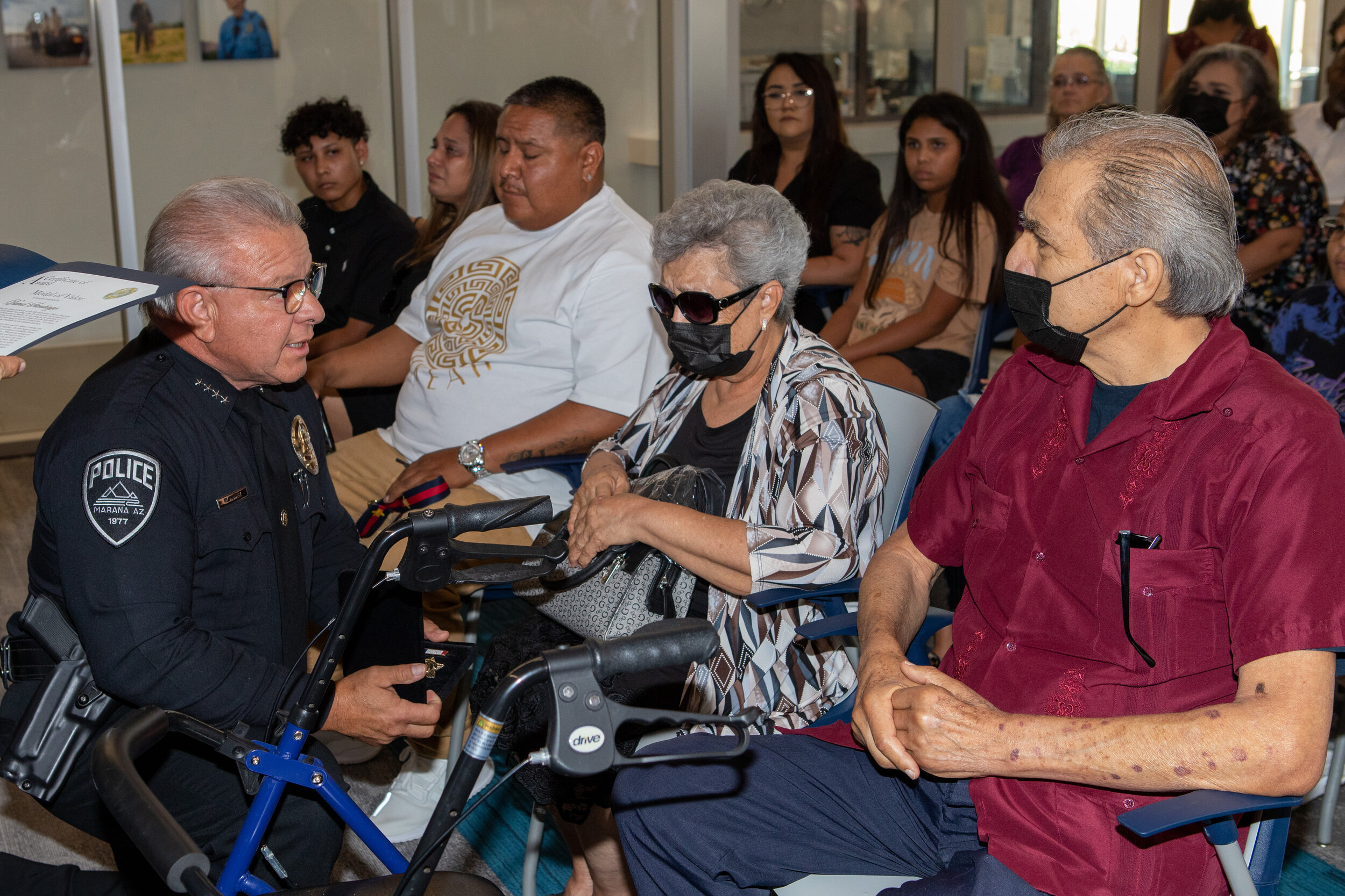 Police Chief Nuñez (left) presenting Medal of Valor to David Santiago's parents (right)