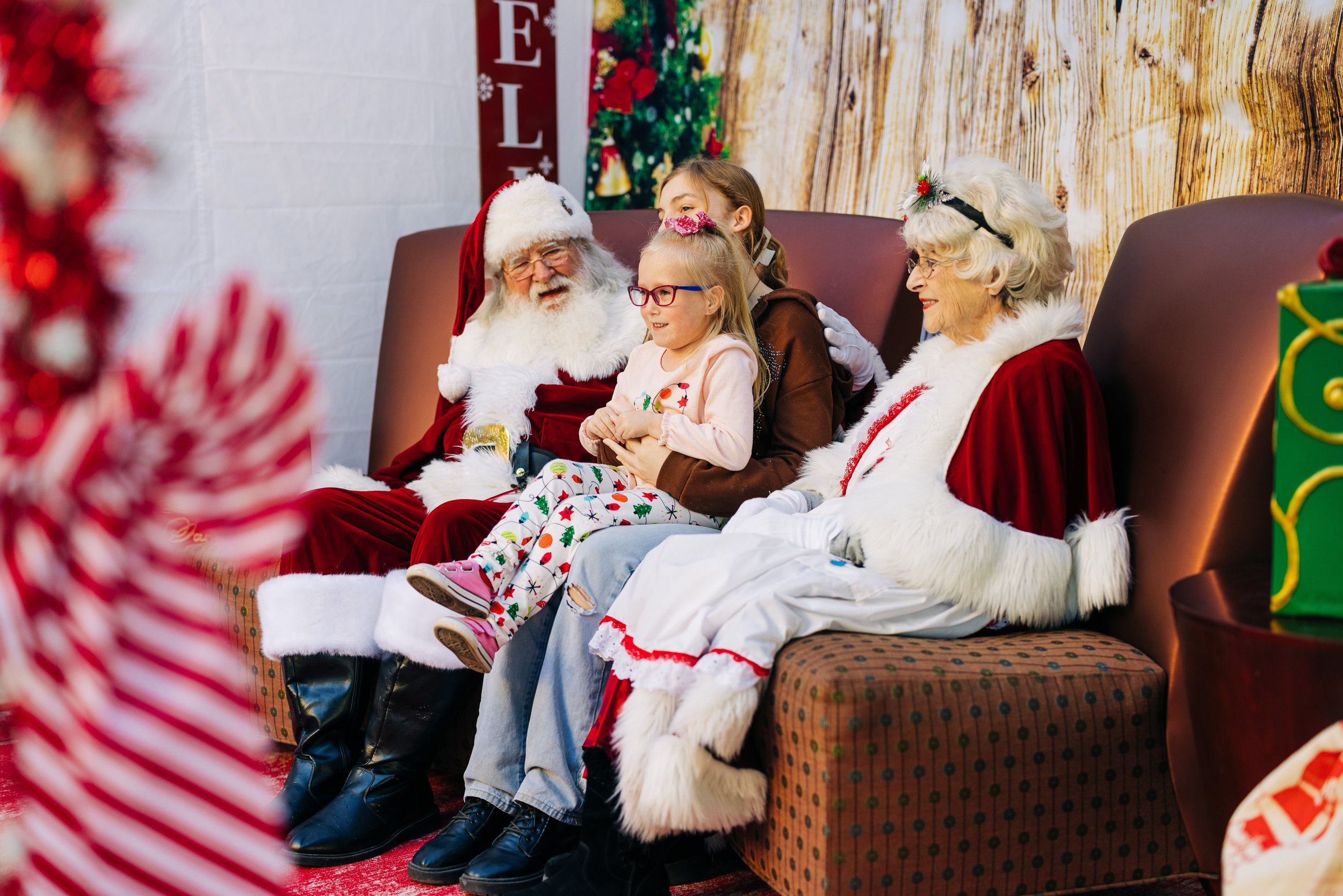 Child poses with Santa and Mrs. Claus