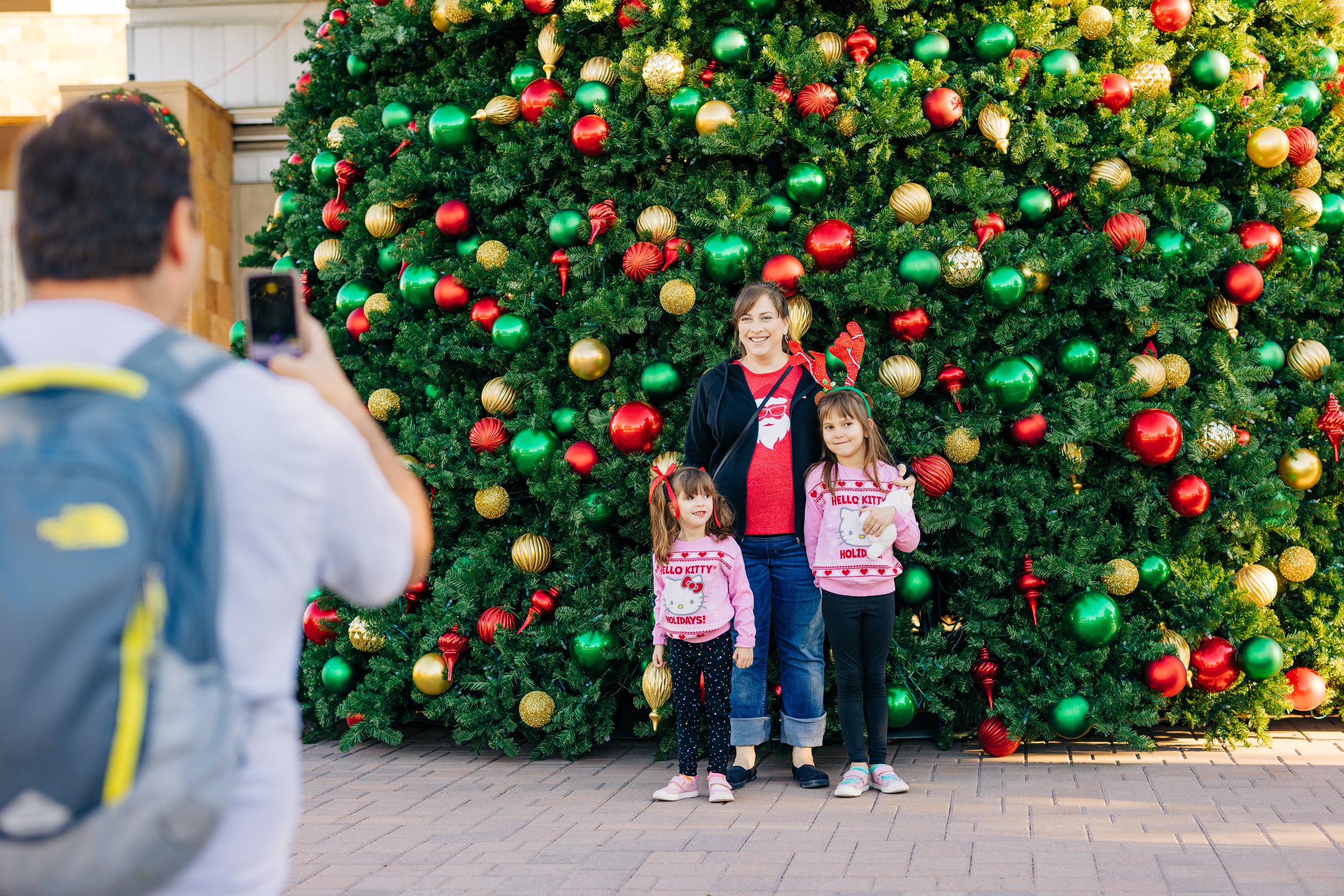 Family poses for picture in front of tree