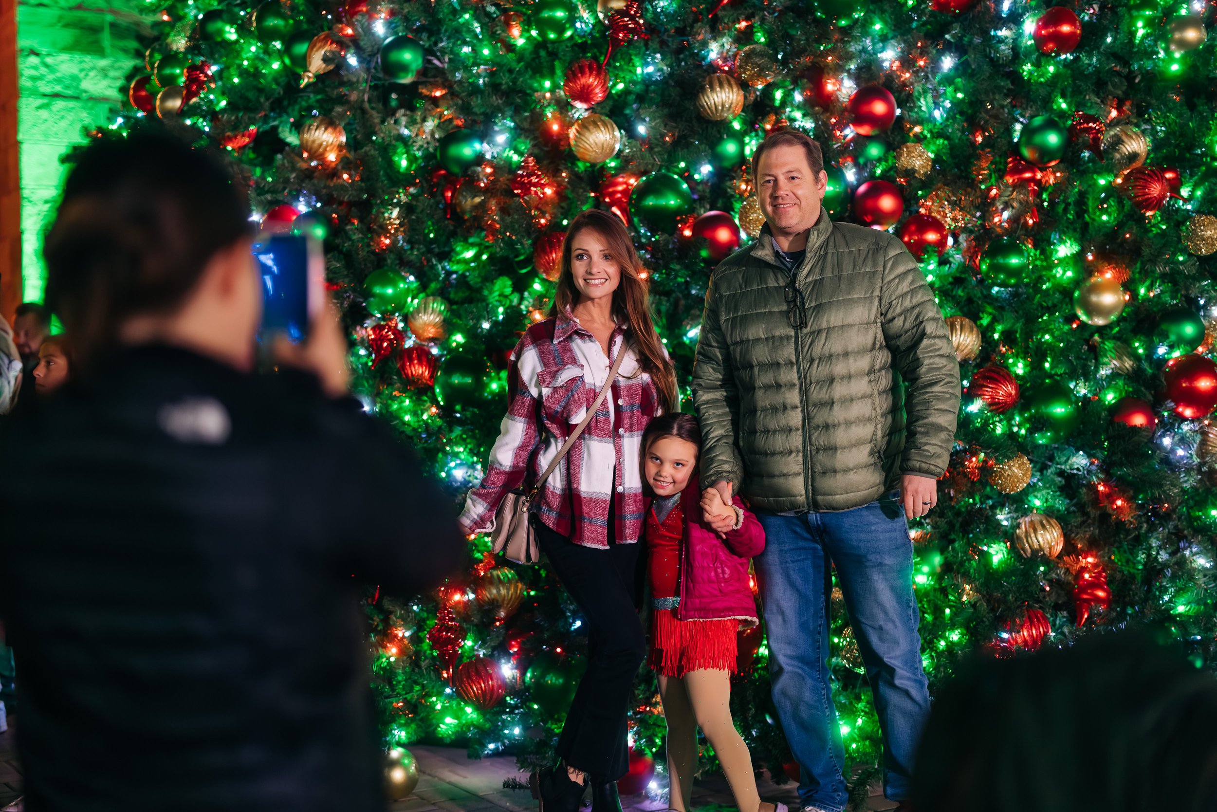 Family posing in front of Christmas Tree