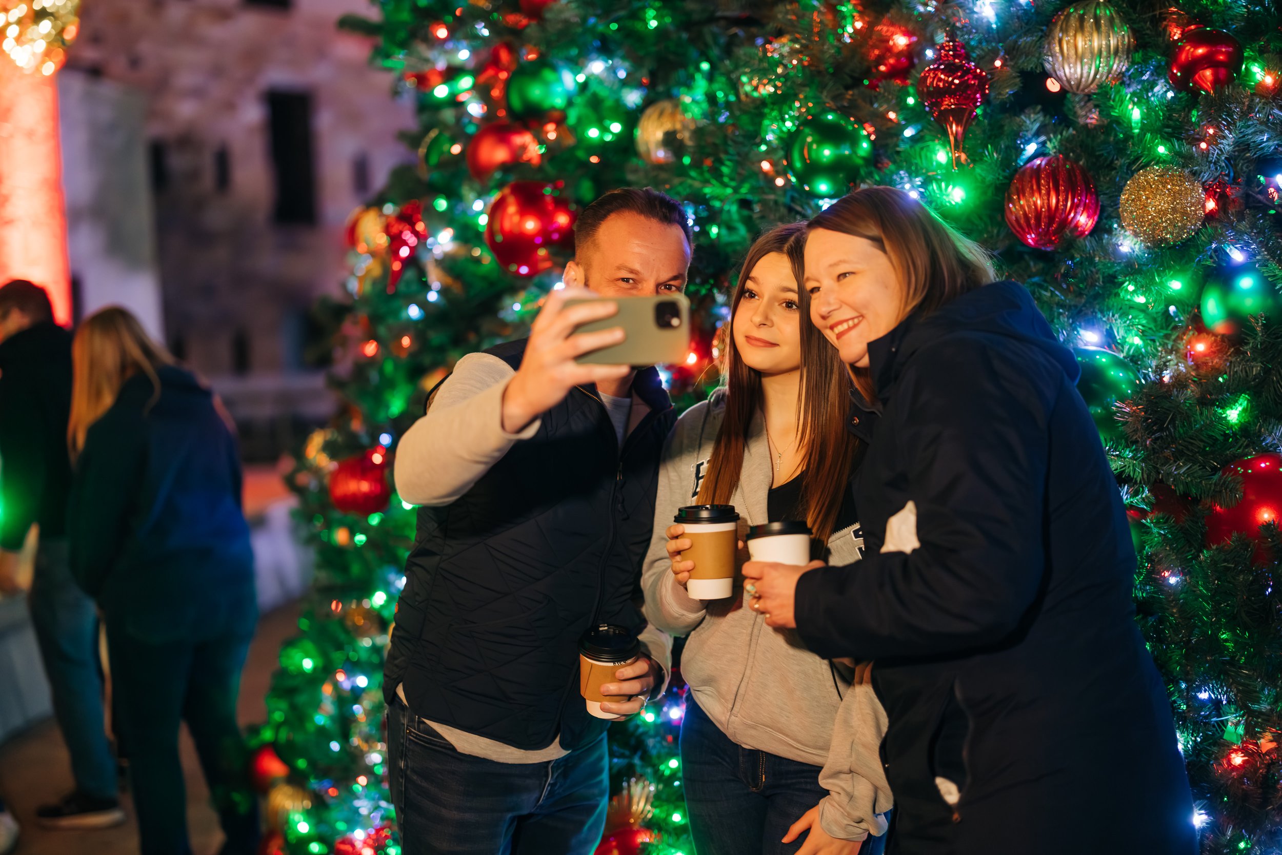 Family taking selfie in front of tree