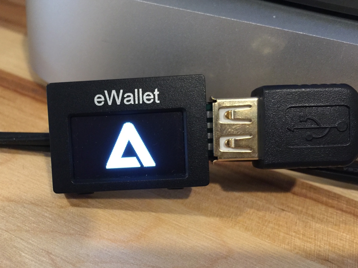 From the boot procedure, it is clear that the eWallet is NOT running a bootloader and firmware compiled by SatoshiLabs (Trezor)