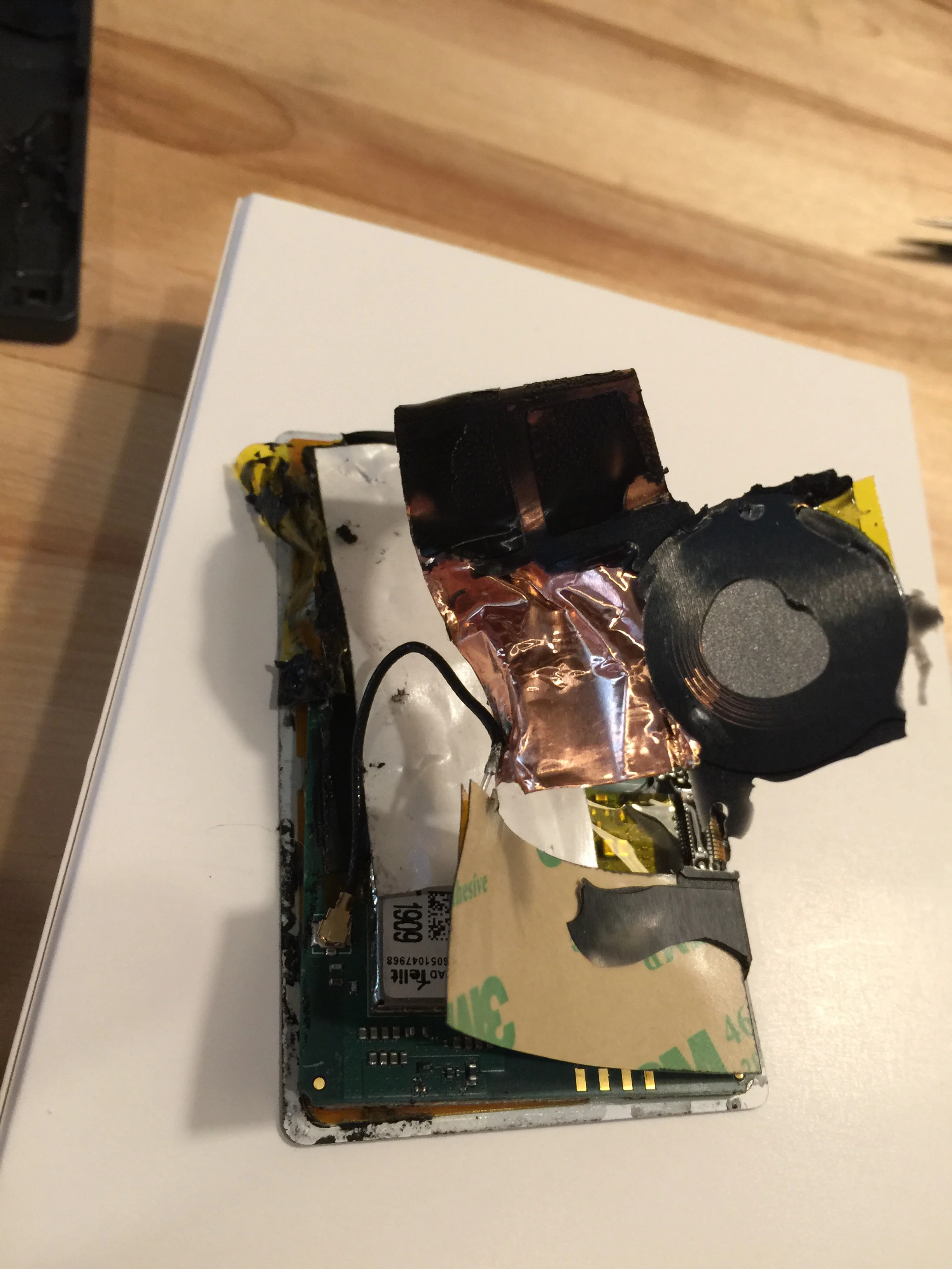 Man, the insides are full of this black sticky tar adhesive. Ugh. The ring there is the wireless charger loop