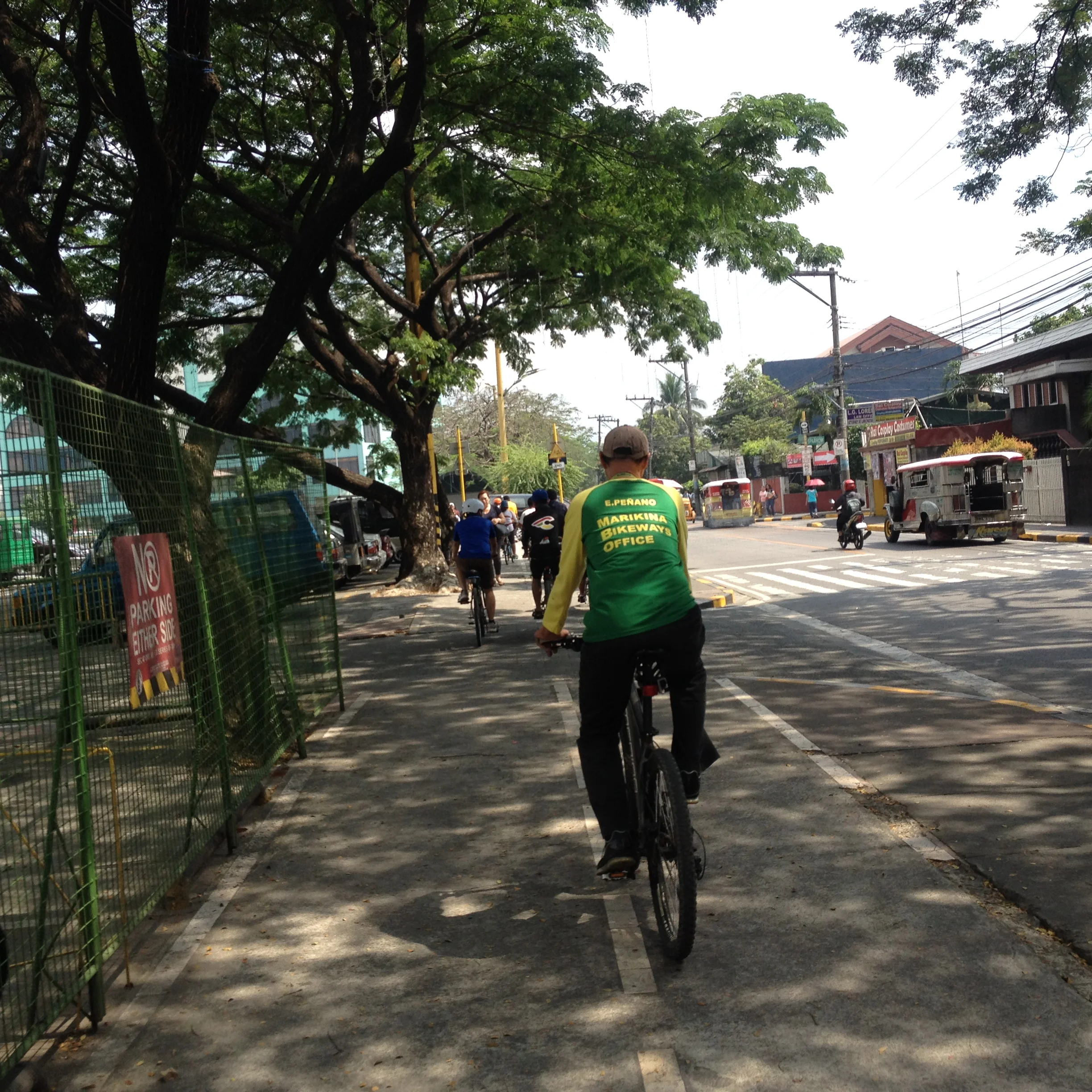 Here a sidewalk lane is appropriate, because it is still at grade with the street, there are no obstructions, and the lane is wide enough for pedestrian use as well. Also here it is shaded which is an ideal consideration. 