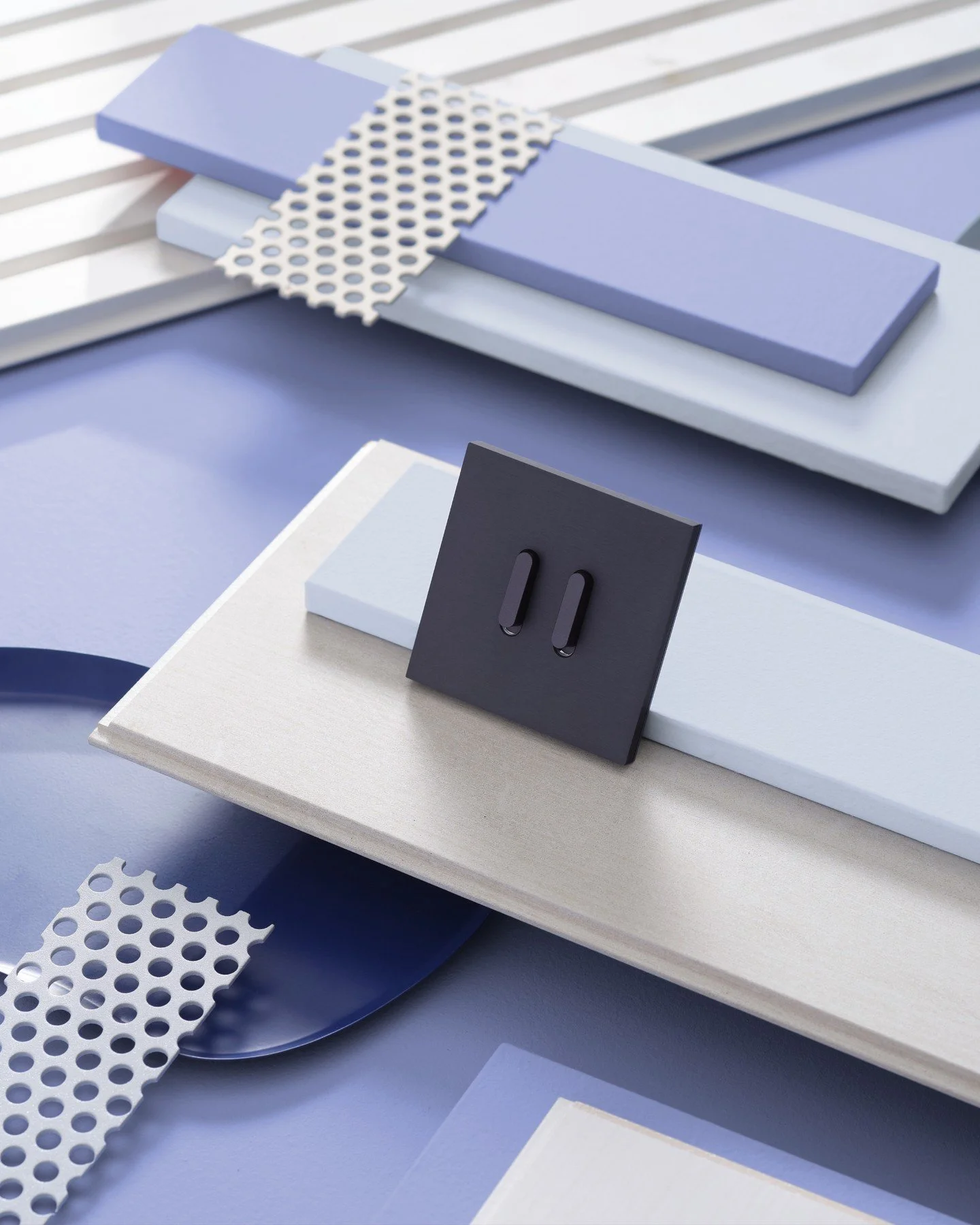 This mood board continues the cool-toned narrative with an added focus on sleekness and contrast. Powdery blues, pale lilac, and soft ivory woods are paired with sharp, perforated metal and a deep navy switch plate, giving it a modern, tech-inspired