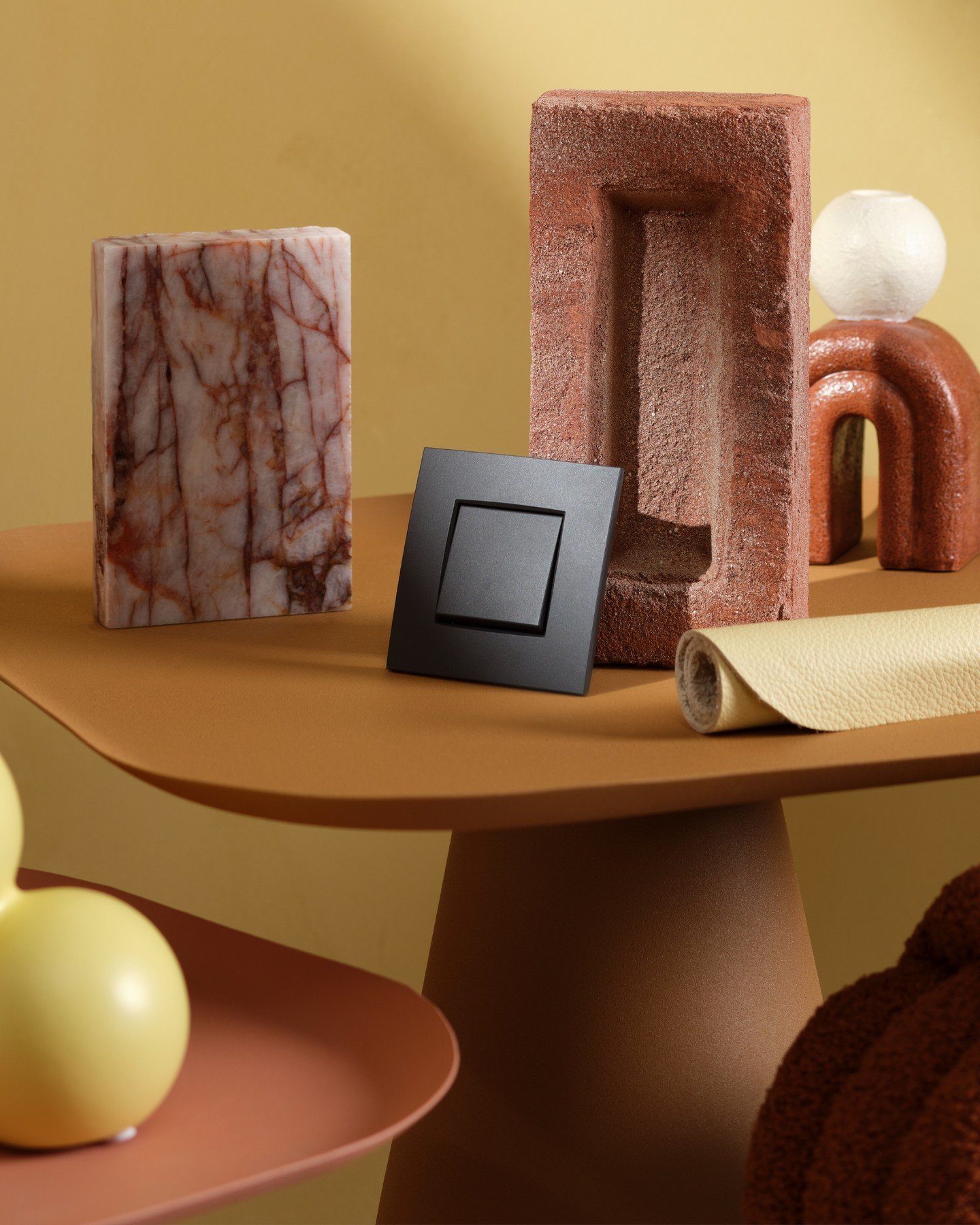 Bold contrast meets warm tactility. This mood board brings together the richness of red marble veining, textured terracotta brick, soft yellow leather, and deep matte black accents. Paired with sculptural forms and earthy tones, each material adds de