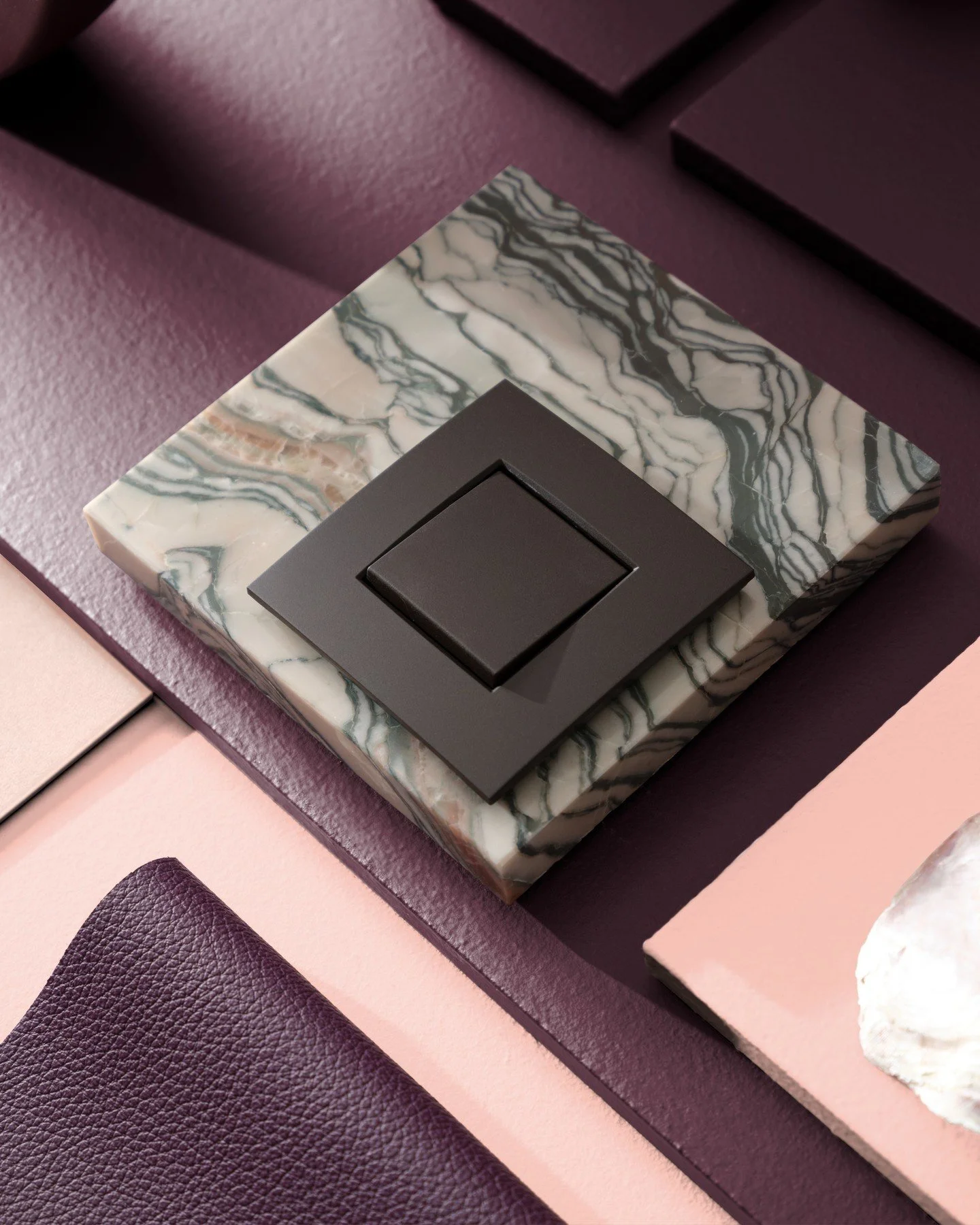 Deep plum and blush pink create a refined contrast, elevated by the rich veins of marble and the tactility of leather. A balance of softness and strength, where polished details meet natural character.