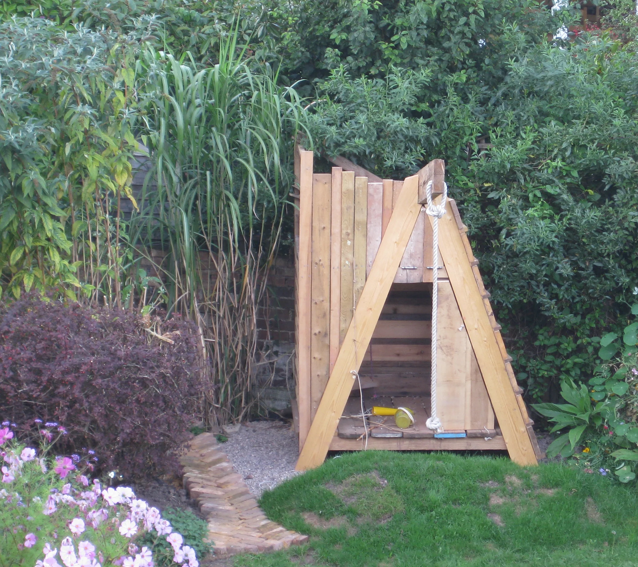 Childrens garden play structure, climbing frame, swing, fort and inner room with drawbridge.