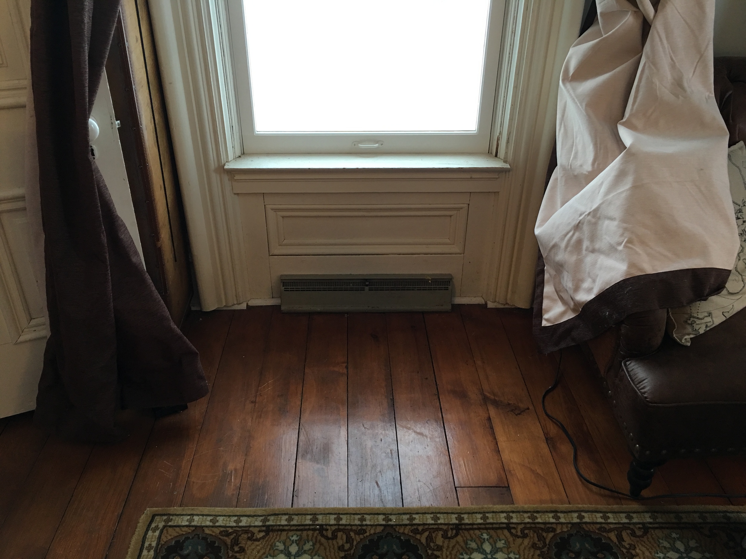 The living room is the only place in the house where the window surrounds descend all the way to the floor, and where there is paneling below the window. (The heating vents were (clearly) added later, with an eye towards practicality rather than attractiveness. The house did not originally have central heating).