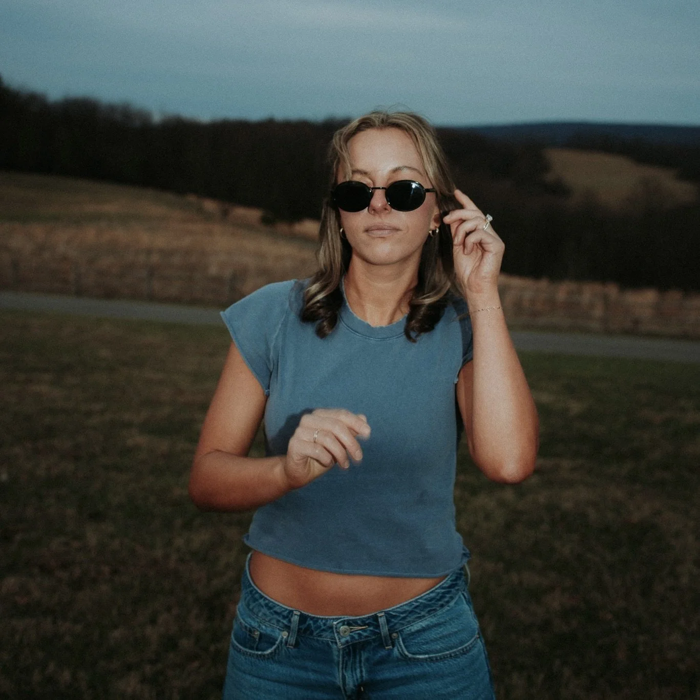girl in sunglasses and blue t-shirt and jeans