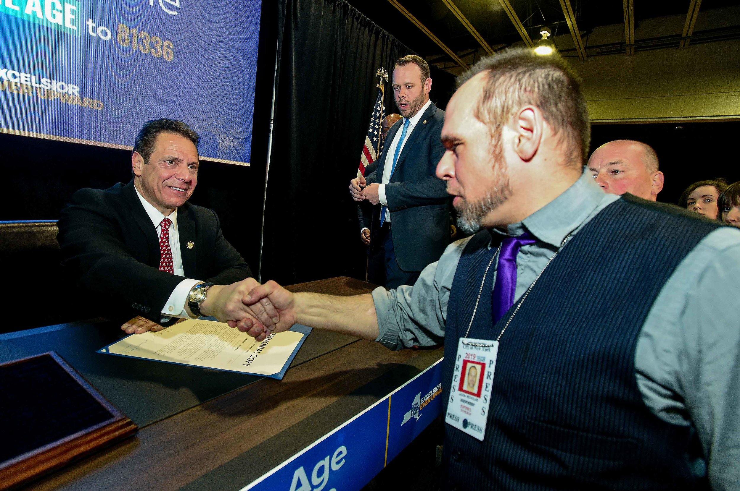On assignment, Gov. Cuomo signing “Raise the Age,” 2016. Photo by Kevin Coughlin.