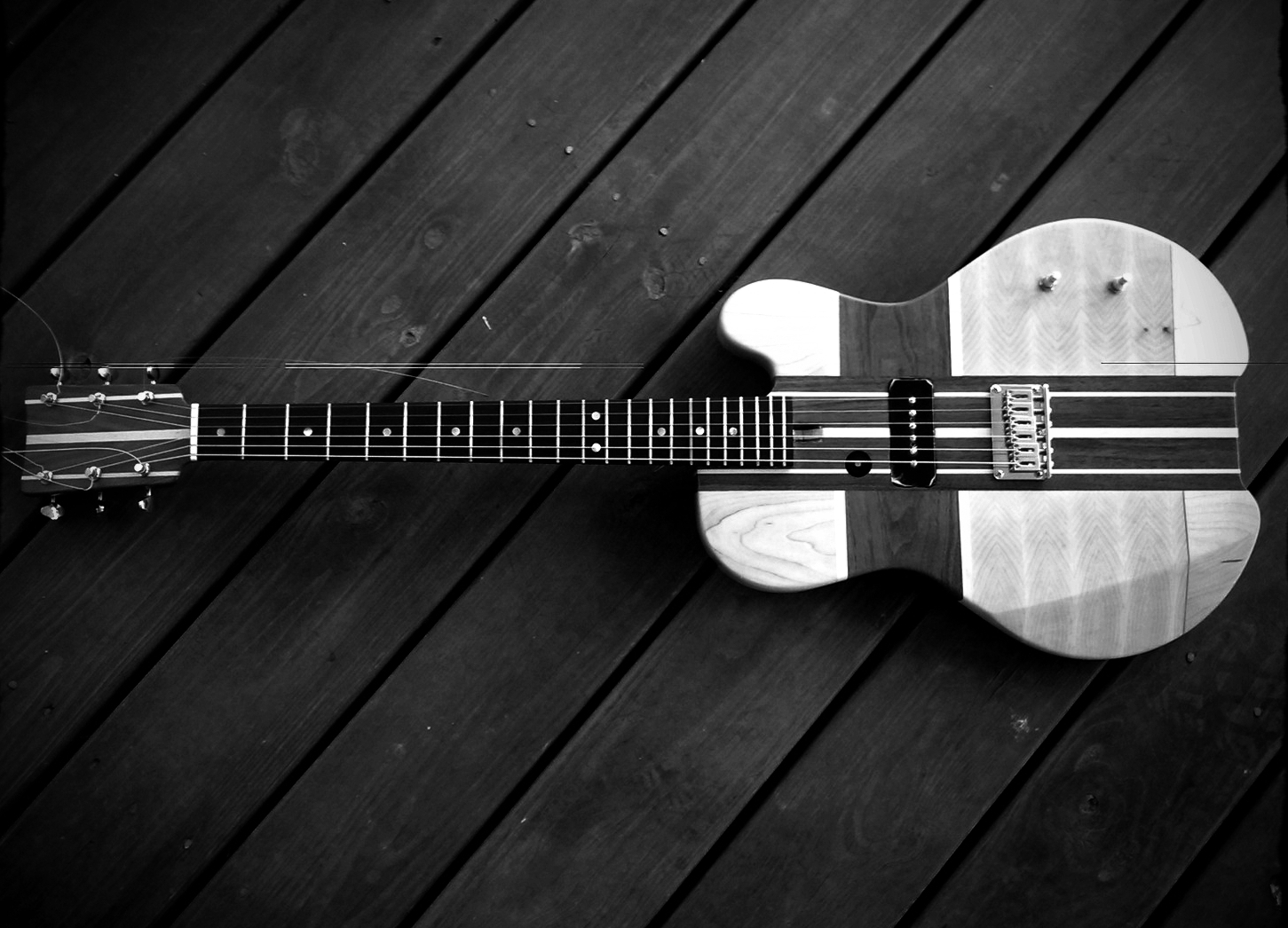 Sleep the Owls was started intentionally as a two-piece with a specific sound in mind. I love my 335, but it just isn't big enough for StO. Necessity begat Grendel, 100% designed and built from scratch for our sound. I'm not into pickup switching and tons of knobs. Here is Grendel, simple, primal, and mean. She has a single P90 pickup placed in middle(ish) position and a volume and tone control to respond to room acoustics. I added a custom single string pickup under the bass string running to a separate output to emphasize the low end. She has a 7 piece hard maple and black walnut neck-through body, with a clear coat to show off the wood work. See below for her origin story.