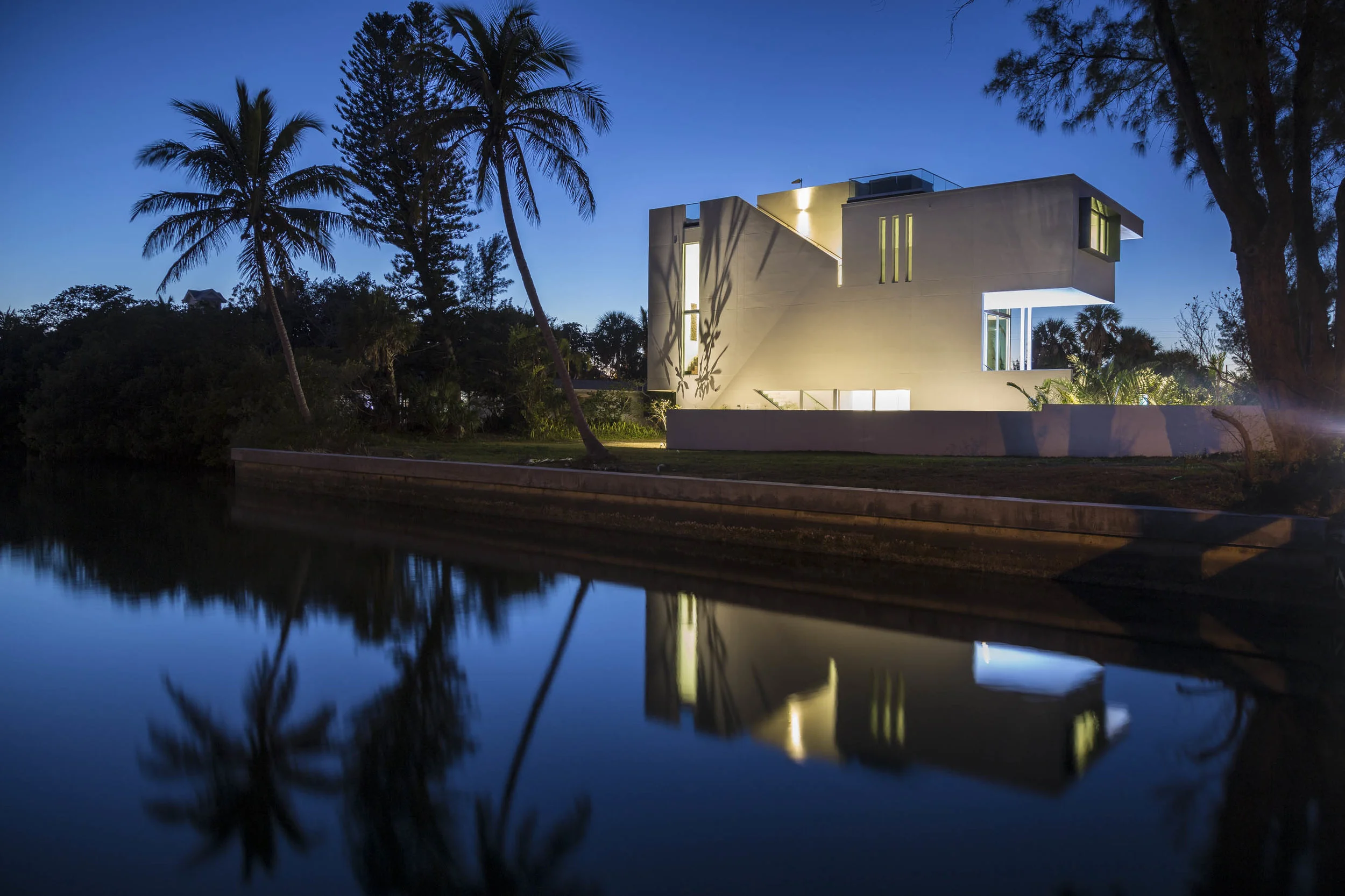 RESIDENTIAL I DESIGN-BUILD Anna Maria, Florida 2018 — American Institute of Architects Gulf Coast 2018 — Mies Crown Hall Americas Prize, IIT, Chicago 2014 — Association of Licensed Architects 2014 — American Institute of Architects Florida Gulf Coast 2013 — American Institute of Architects Tampa Bay The site is a 56 foot wide parcel facing the public beach across Anna Maria Island’s coastal drive. The land is the middle parcel of a subdivided lot with two adjacent properties also under development. The 3,500 square foot proposed residence is closely bounded by the four setback lines and is elevated a full story to meet a high flood elevation. The site is accessed by an alley shared by the three newly created lots at the back of the site. The intent of the design was to reconnect the elevated house with the yard below. From the raised living space, the house first descends three steps to an elevated pool to again step down another half flight of stairs to a wood deck three feet above grade. The wood deck in turn steps down with stadium seating to the yard and the entry gate. This allows the house to expand to shaded exterior spaces visually connected to the interior. Two double height volumes placed at opposite corners of the floor plan tie the living levels together and add spatial interest to the circulation. The office on the top living level looks through the double height living down to the pool below and the beach beyond. A roof terrace, accessed by an exterior stair, provides a private outdoor space in proximity to the master suite. A large cut in the roof offers a view down to the pool and the yard below.