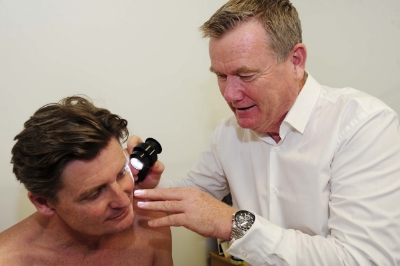 Dr Chris Boberg using a dermosocope to check moles