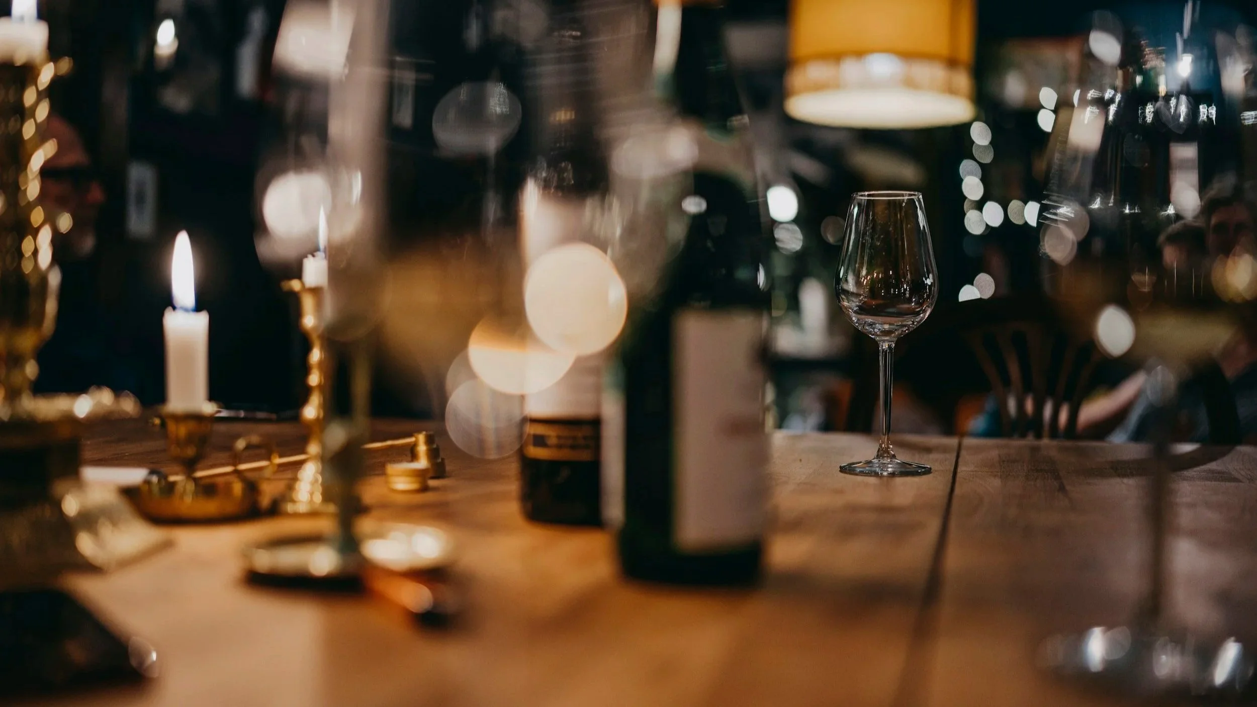 wine glass, bottle and candle on table
