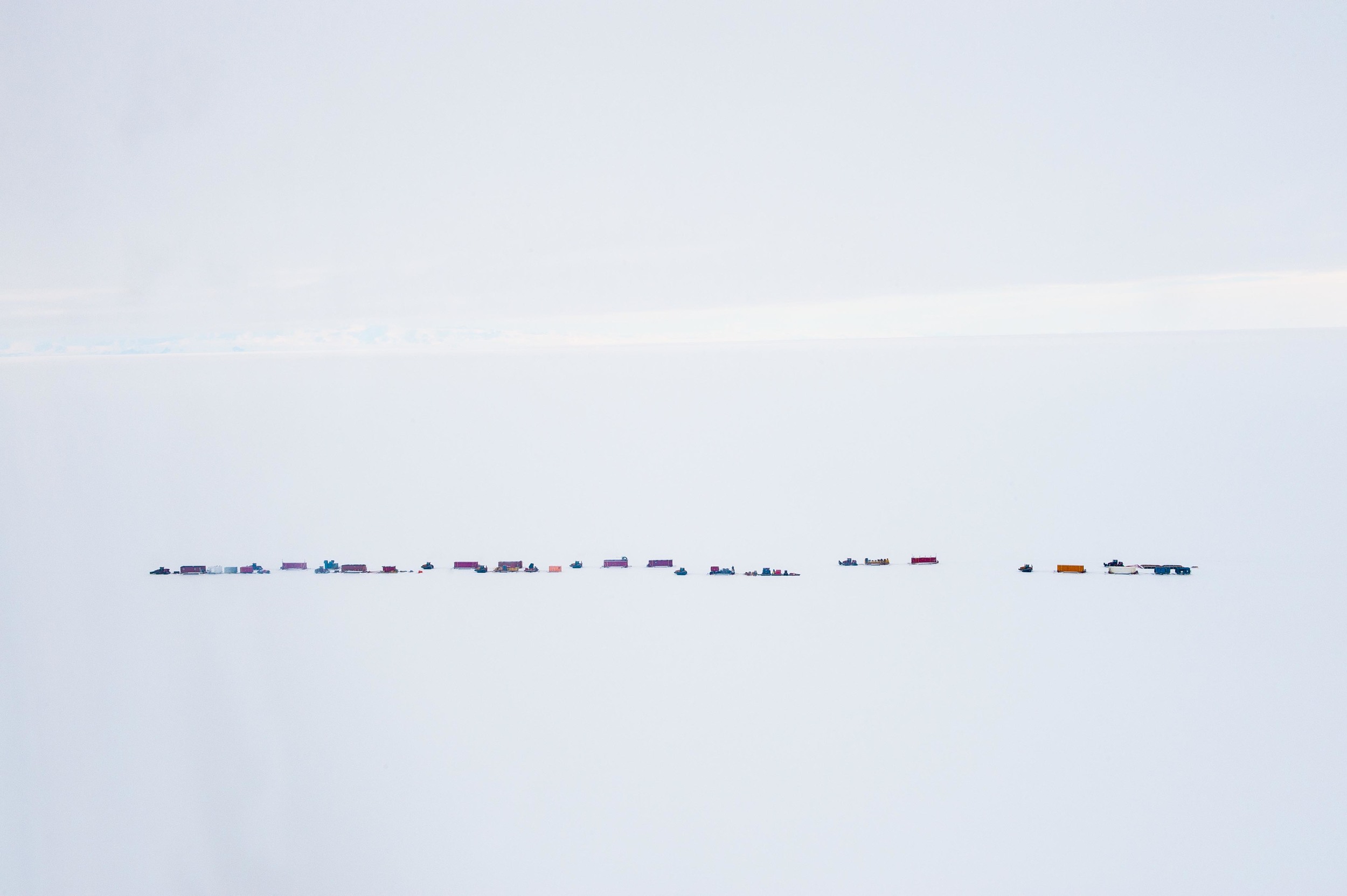 The traverse of equipment makes its way across the ice. PHOTO BY J.T. THOMAS