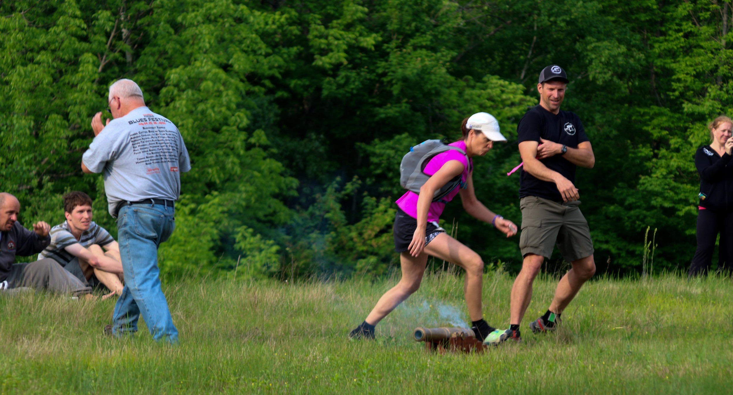 Runner Linda Bahnson and race director Andy Weinberg run from the cannon that was used to start the 88k race.