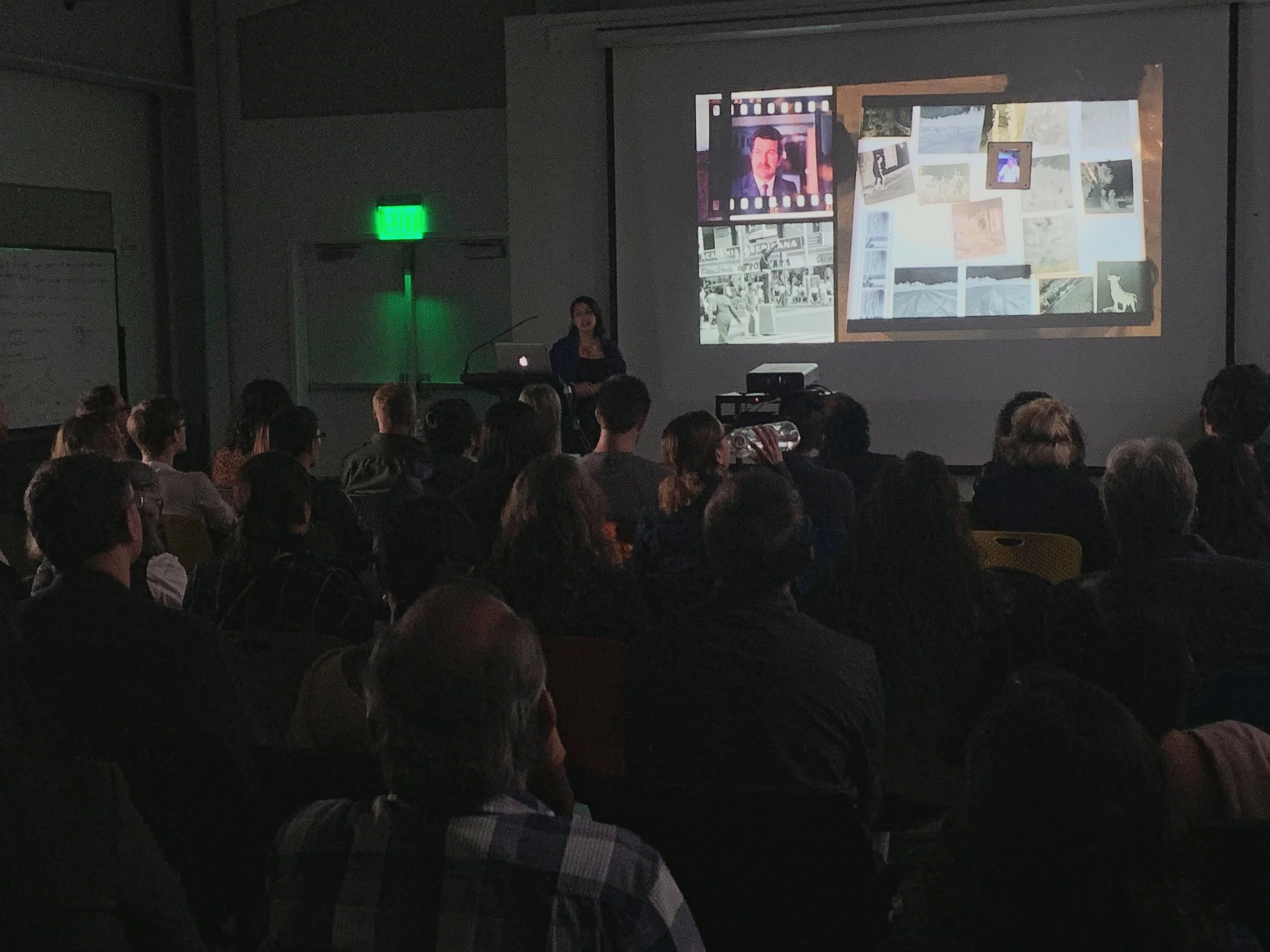 A dark, candid photo of me giving my artists’ talk.