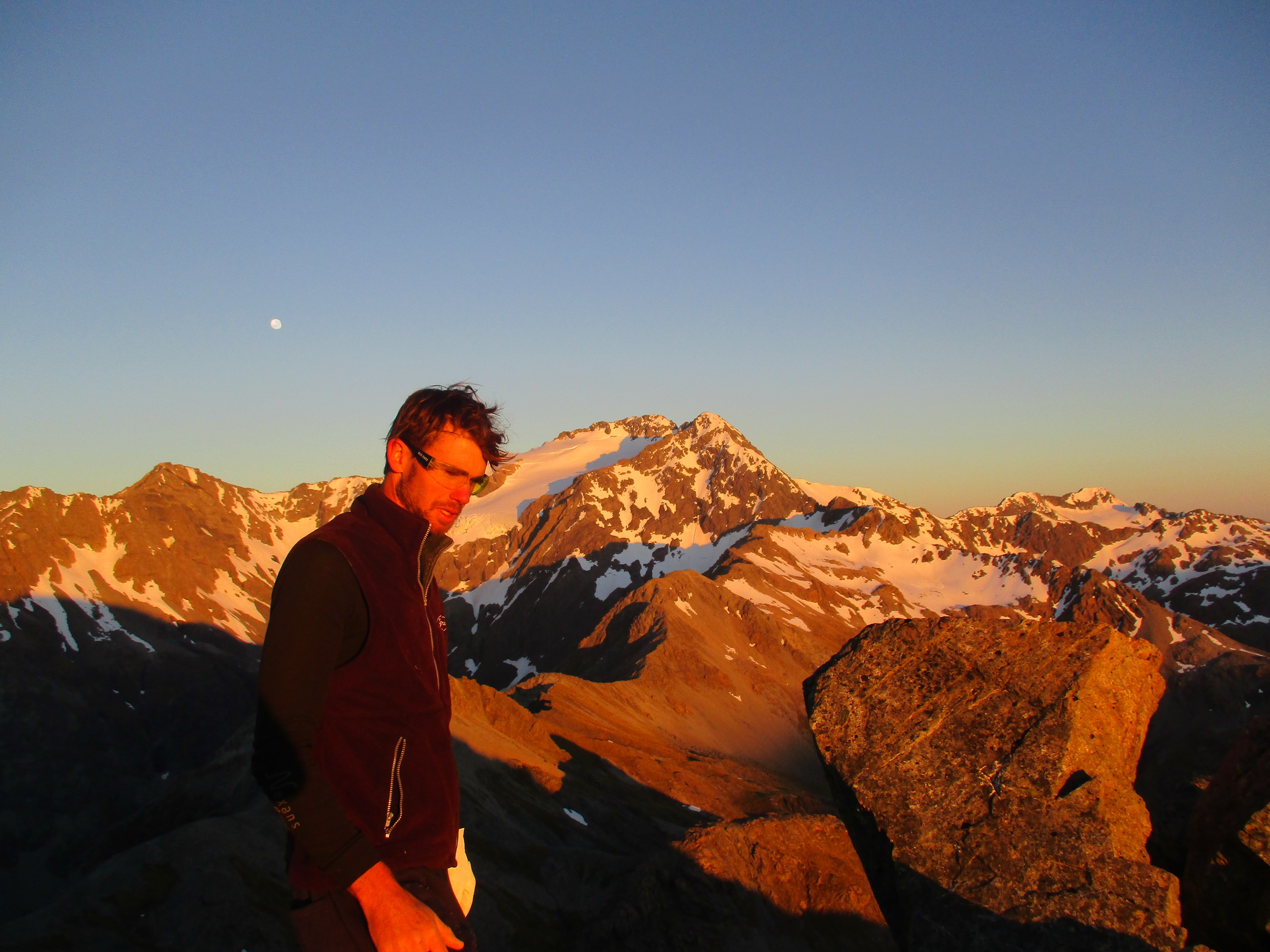   Dawn on Avalanche peak, Carl waking up from our bivvy with Mount Rolleston 2275m behind  