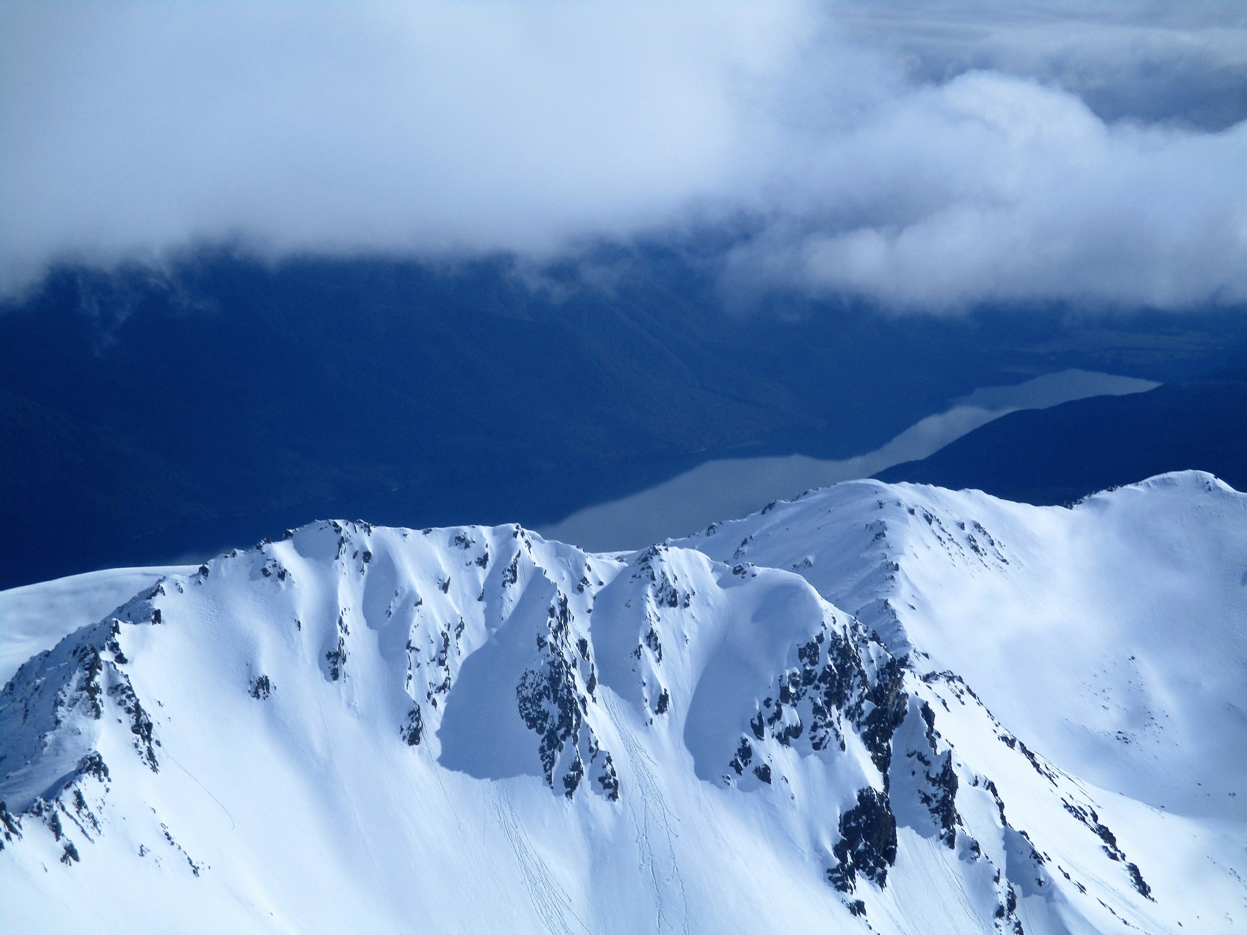A month later on a solo trip looking out from the summit of Mount Angelus down to Lake Rotoroa the snow conditions were quite different as were the meteorological conditions and this was a rare break in snow showers and claggy cloud that day.