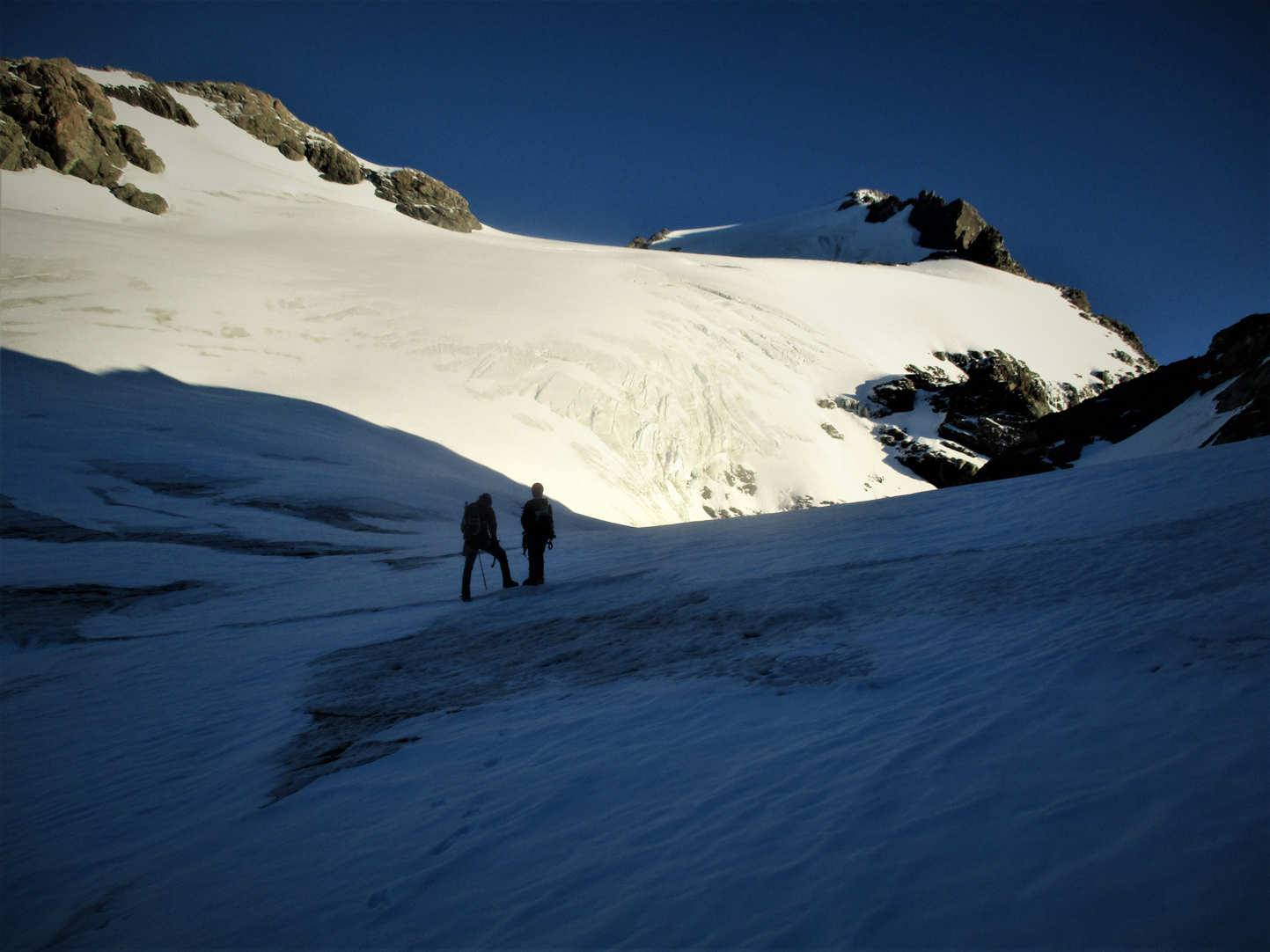 Up till now as we began catching the early morning sun the climb up the Veil had been easy ,too easy maybe. It was my first time on a Glacier in almost 2 years and the last time was the chaotic mass of the Baltoro whose only similarity with this one was some ice underfoot. Ben had done all the planning leading up to the trip and now Jerome as doing all the leading up the mountain. I was ambling along in la la land enjoying the soft ice cream glacier - even the Bergschrund ( a large Crevasse) was filled in with all the recent snow. Looking up the summit route seemed quite clear but one worry remained , a traverse over ice cliffs looked imminent.