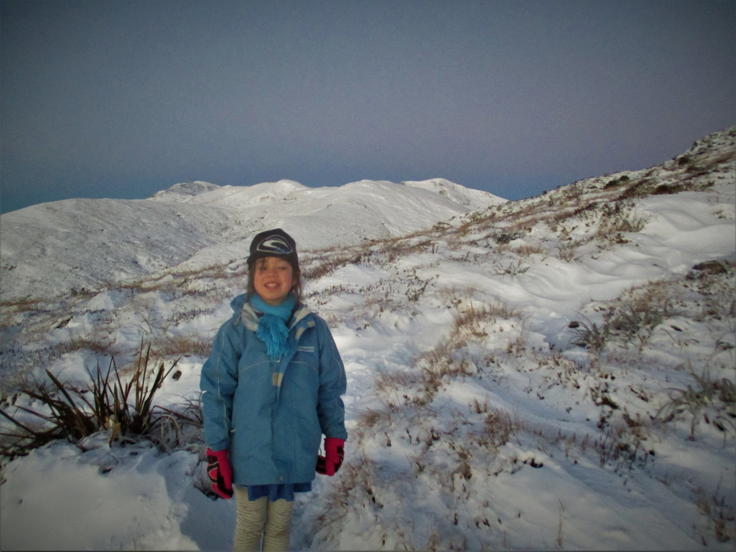 Isabelle on Mt Arthur at dawn , catching the first snowfall of the year.