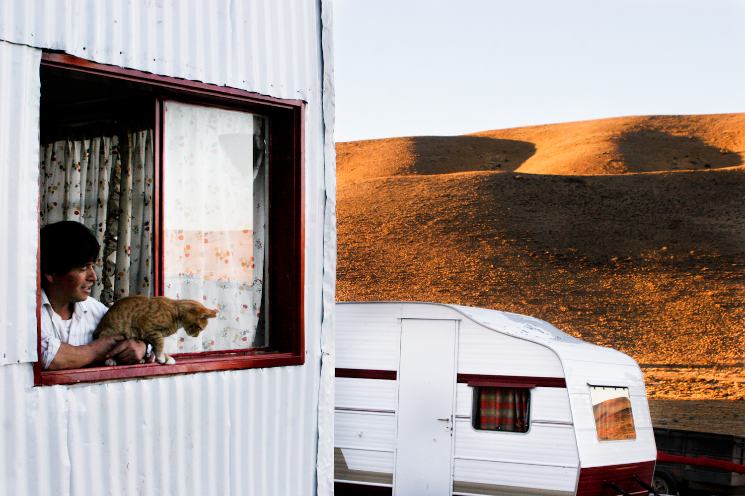 A man and his cat at home in the middle of Patagonia. 