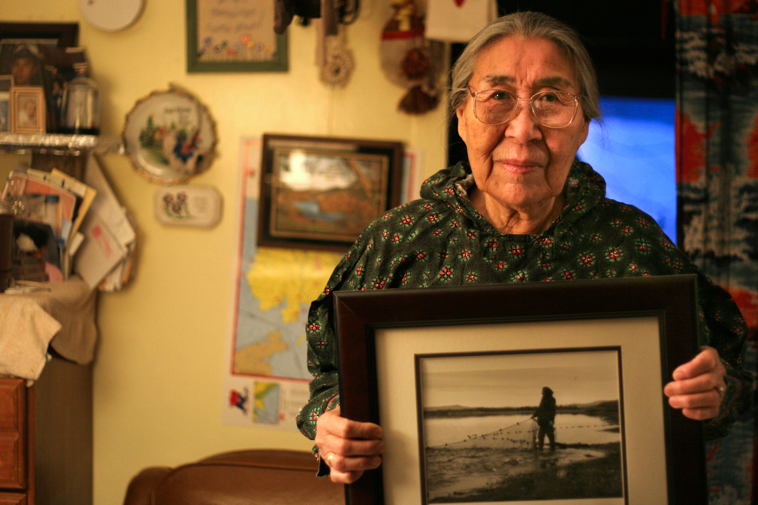   Minnie Gray, 73, was one of the first seven families to move to Ambler from one of the northern villages. She holds a photograph of when she was younger, seining whitefish and sheefish along the shores of Ambler River. "Things have changed, so many