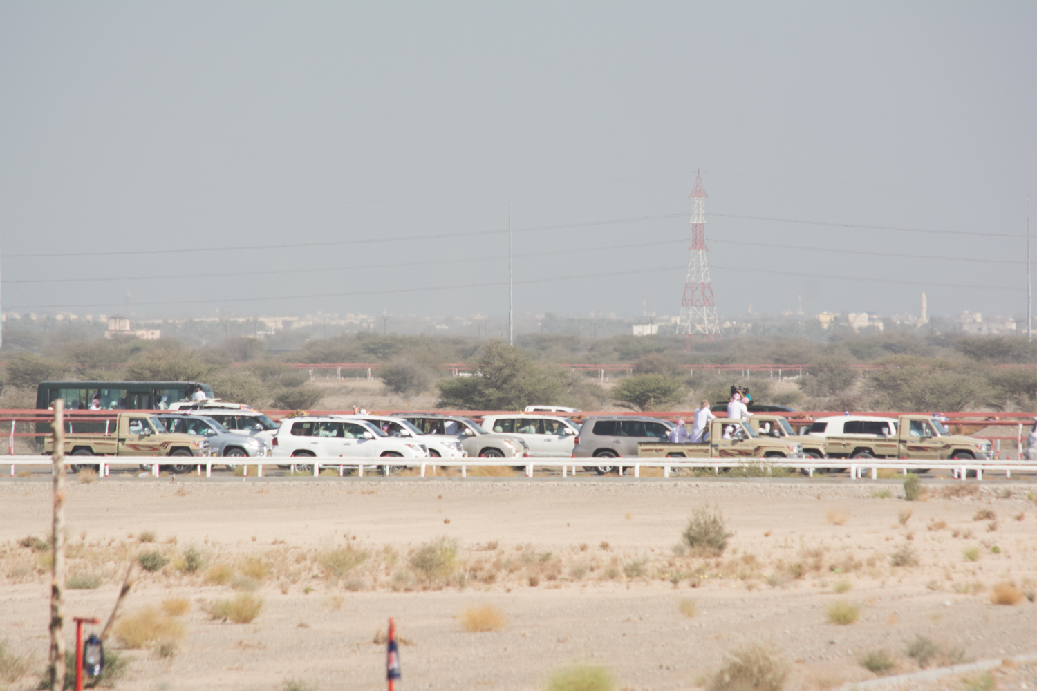 Camels & chaser cars crossing in the distance.