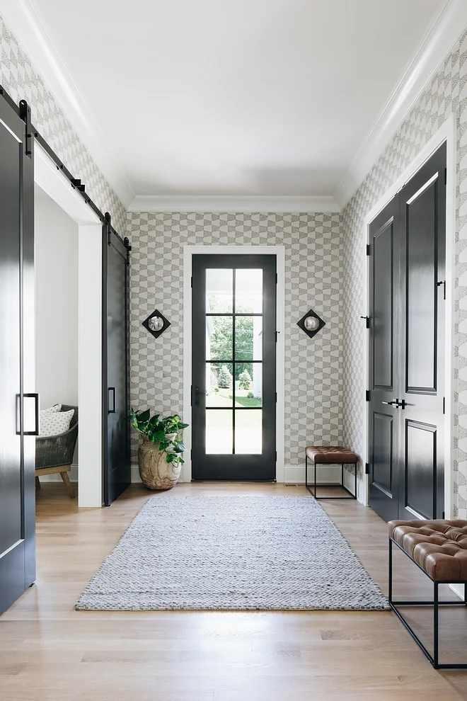 Black doors are painted in “Benjamin Moore Wrought Iron” and wallpaper is by Thibaut.
