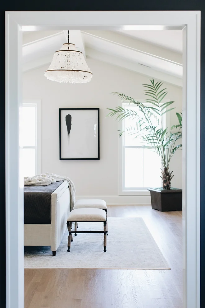 Double doors open to a master bedroom with vaulted ceilings.